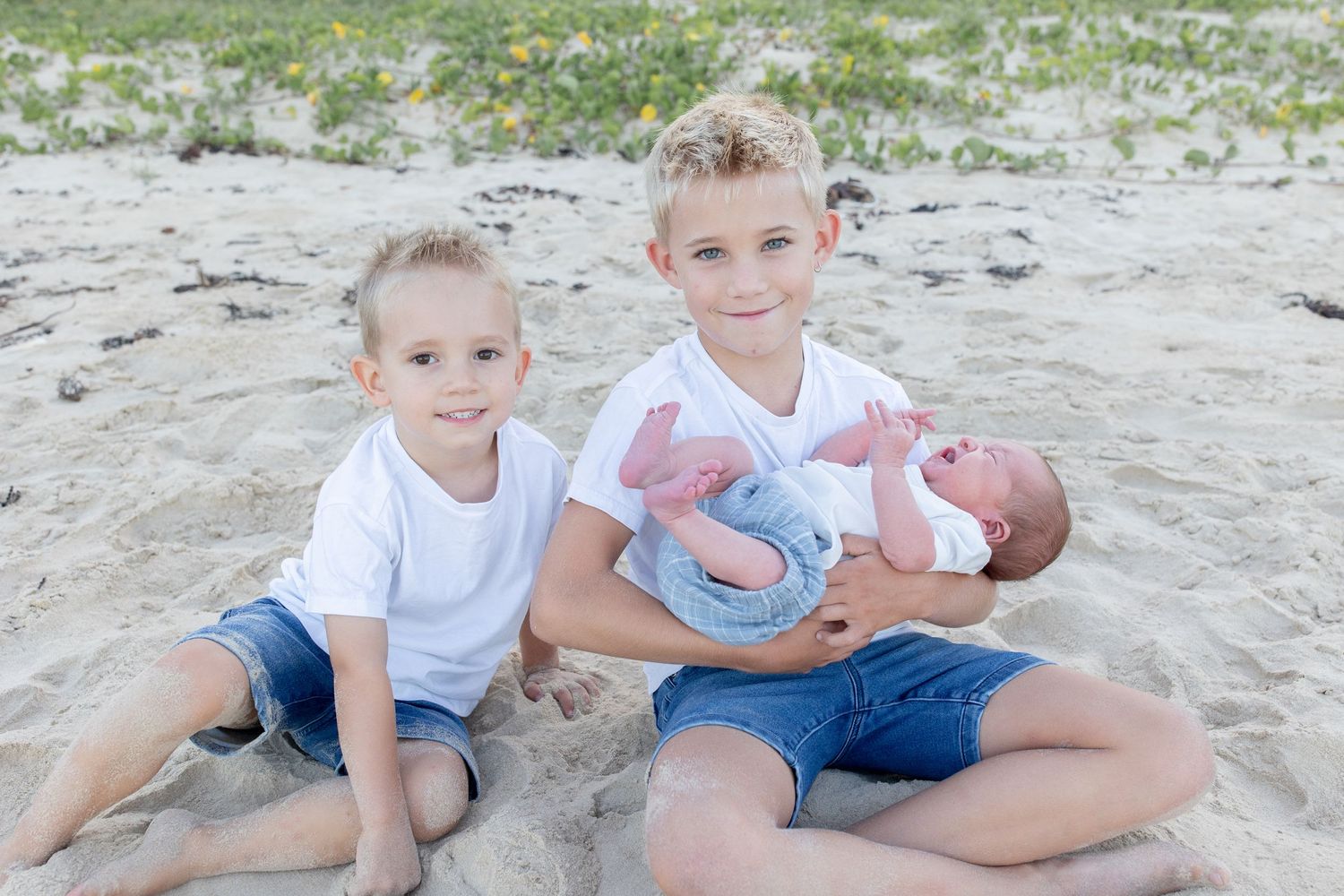 Coastal newborn session with family, featuring candid moments and gentle light.