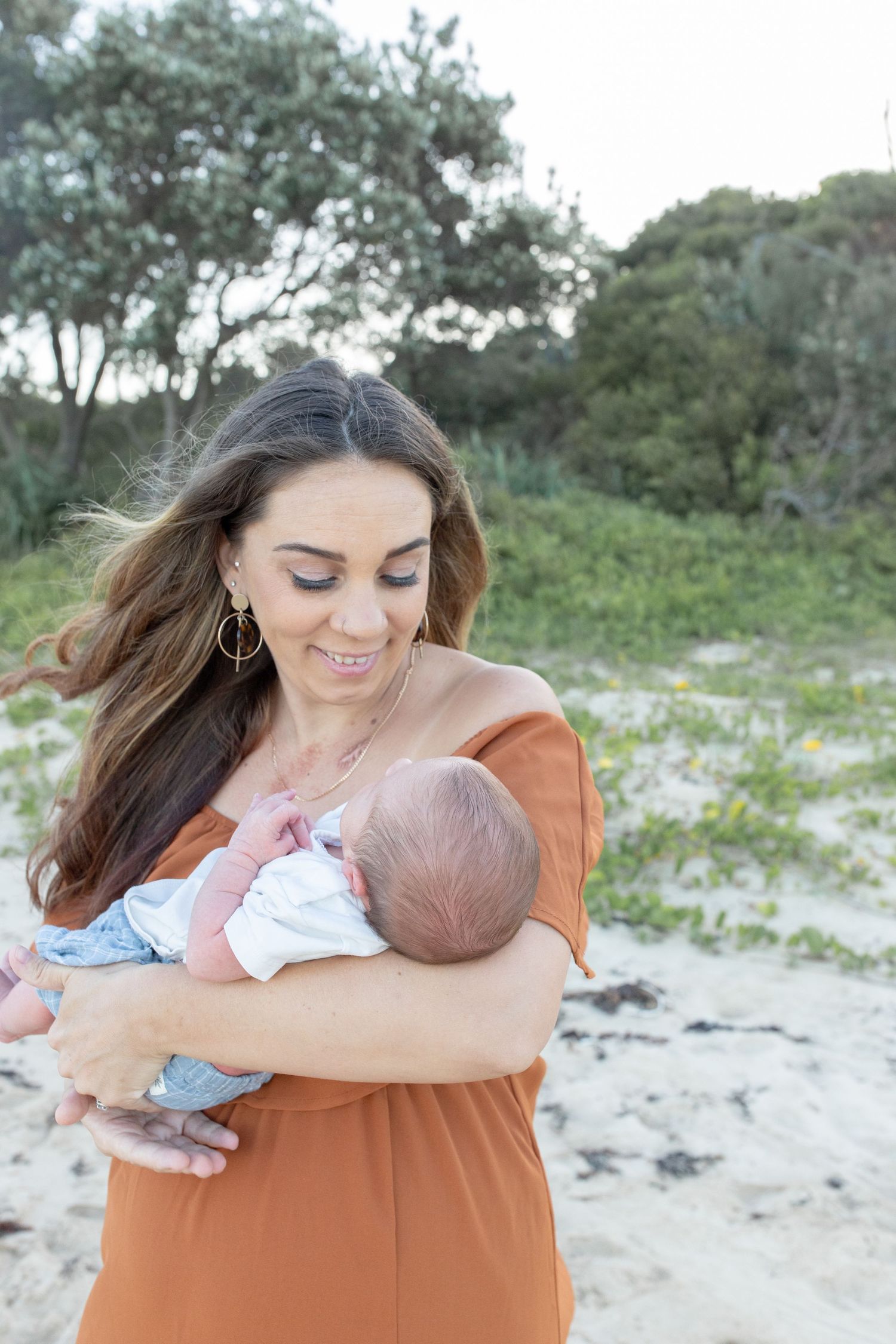 Lifestyle newborn photography at the beach, capturing gentle, coastal tones.