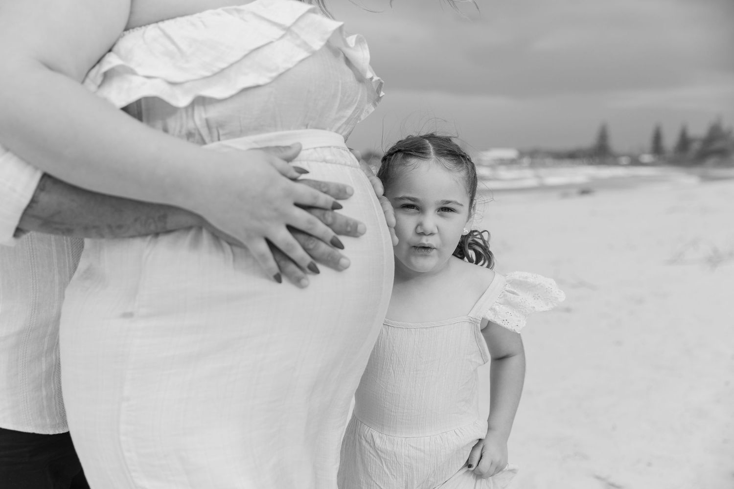 Black and white portraits showing tender moments between two people in white attire.