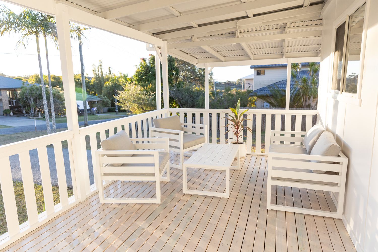 Spacious white deck with outdoor furniture and coastal views.