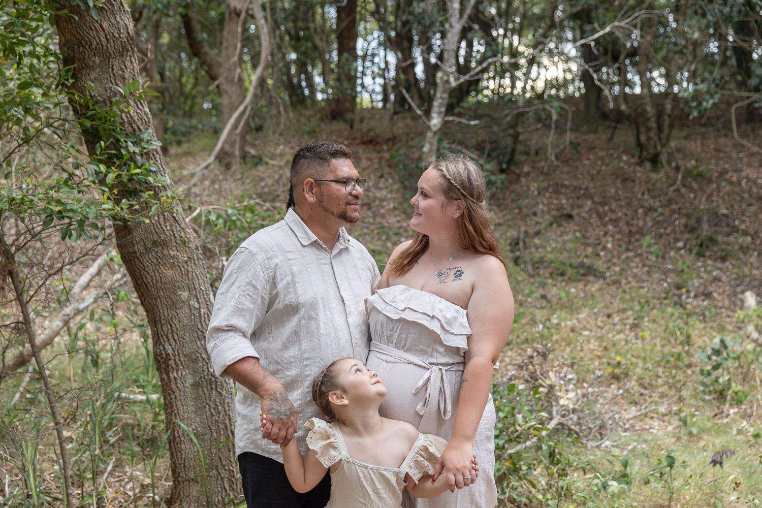 A family shares joyful moments together during an outdoor photo session among trees.