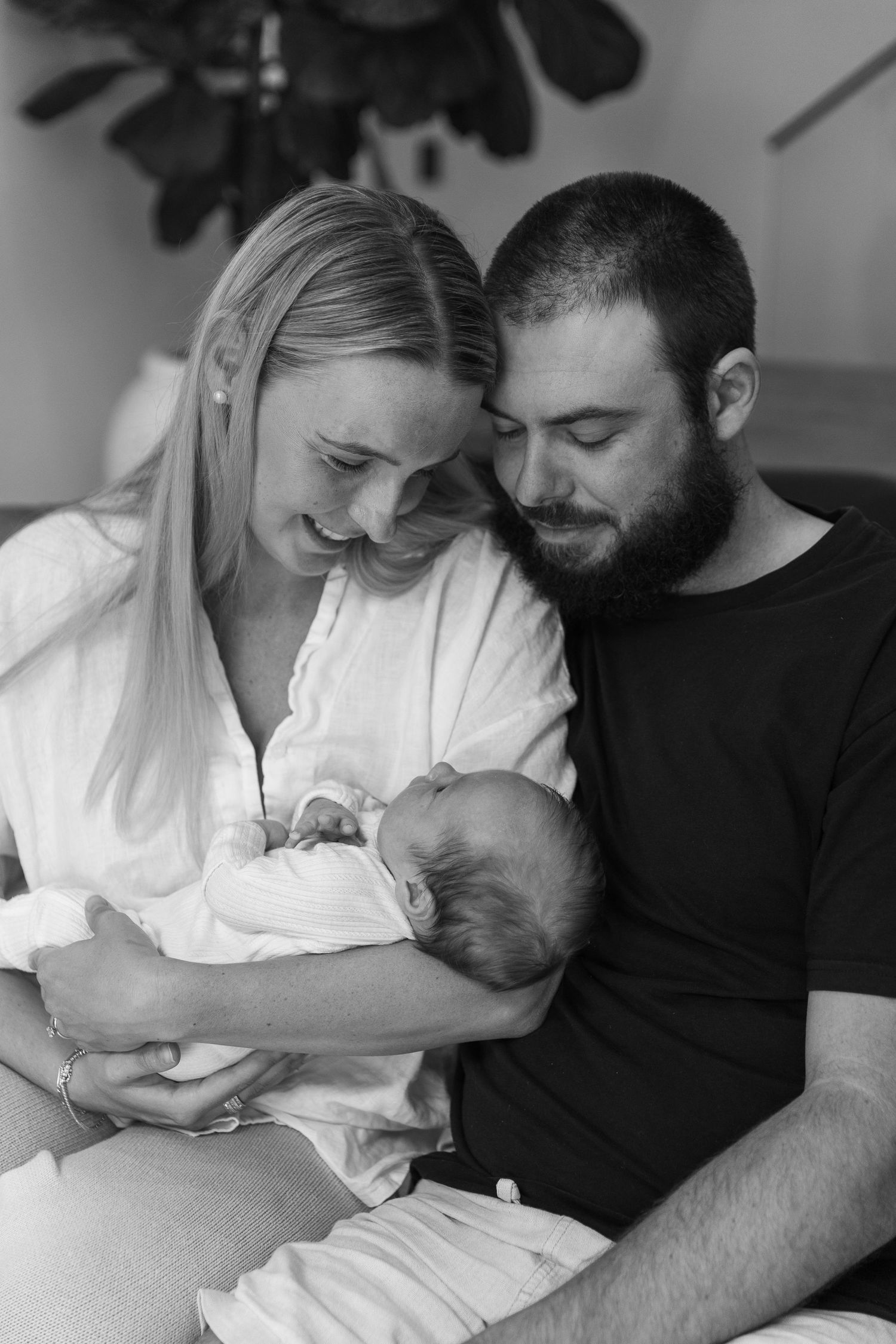 Intimate black and white photo series of parents bonding with their newborn.