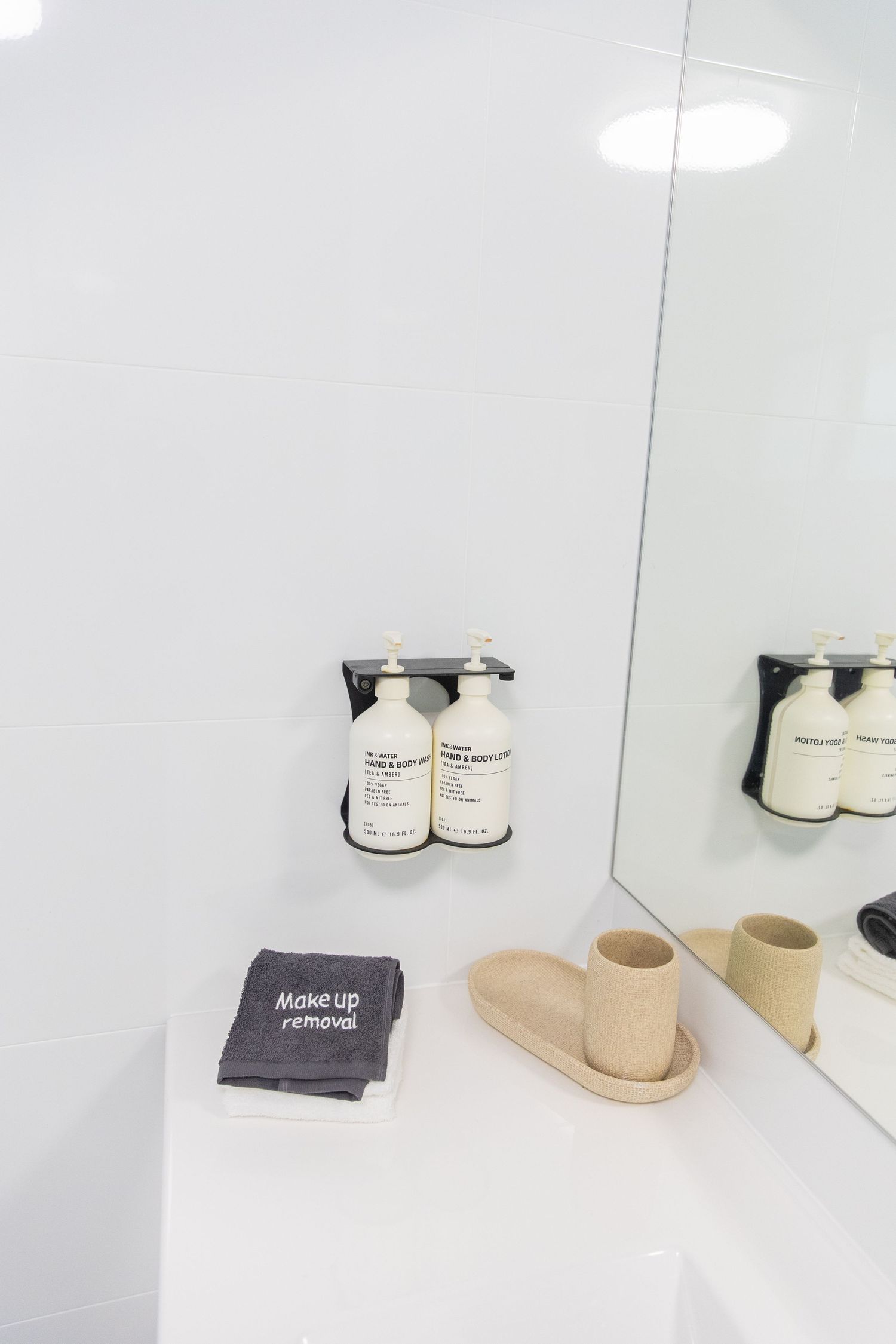 Clean and minimalist bathroom shelf display with white towels and natural decor elements.