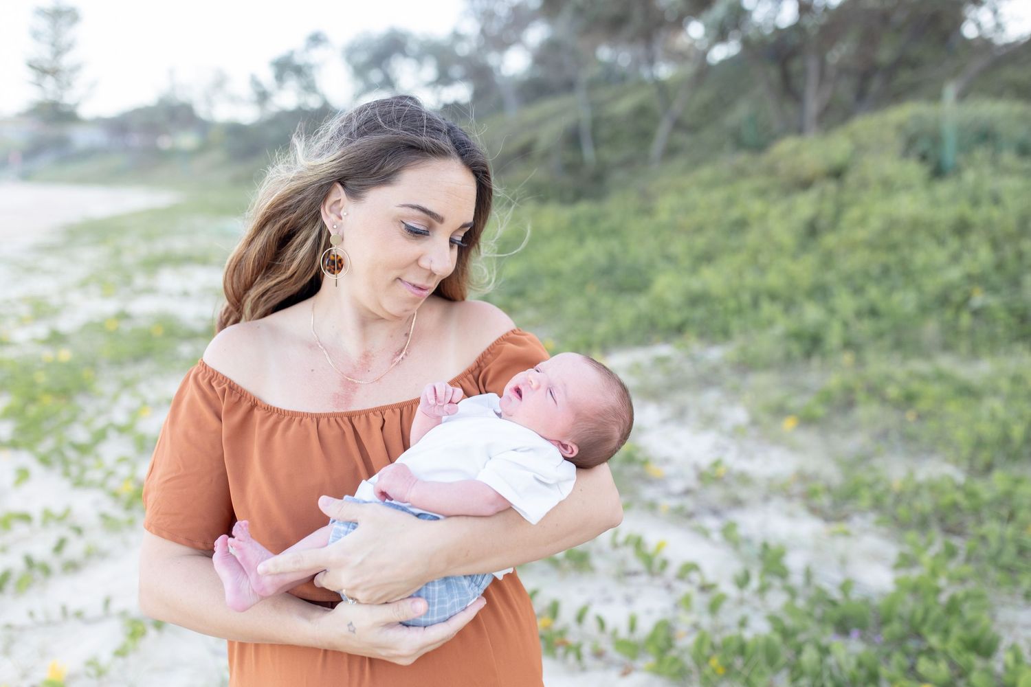 Candid newborn photo by the ocean with natural coastal light on the Coffs Coast.