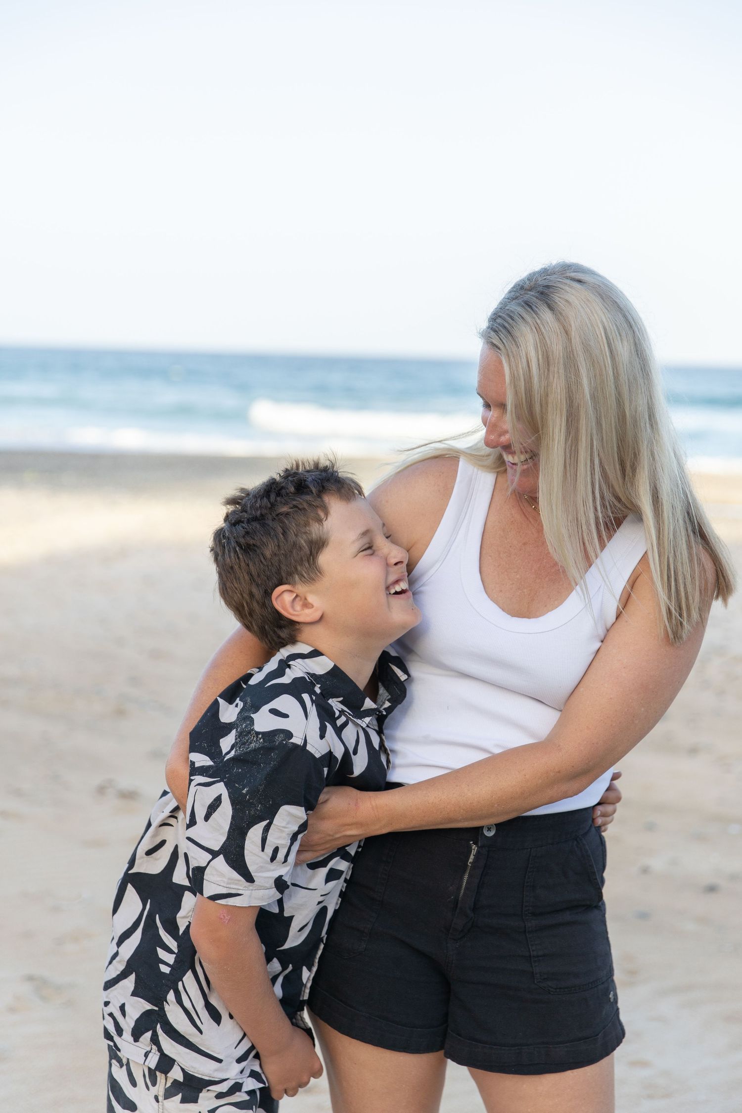 Heartwarming beach moments captured in black and white showing family affection.