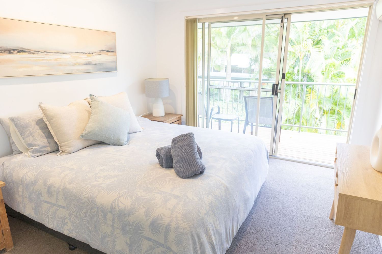 Bright and airy bedroom with white linens, natural light, and coastal decor accents.