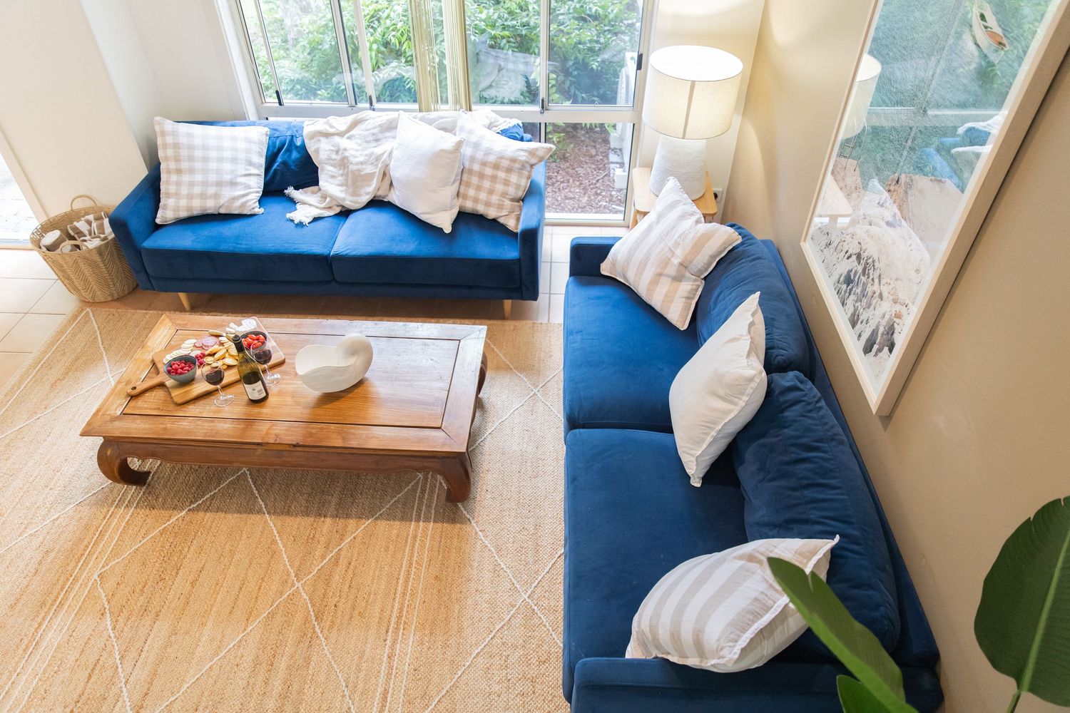 Contemporary living room featuring blue sofa, coastal decor, and natural lighting.