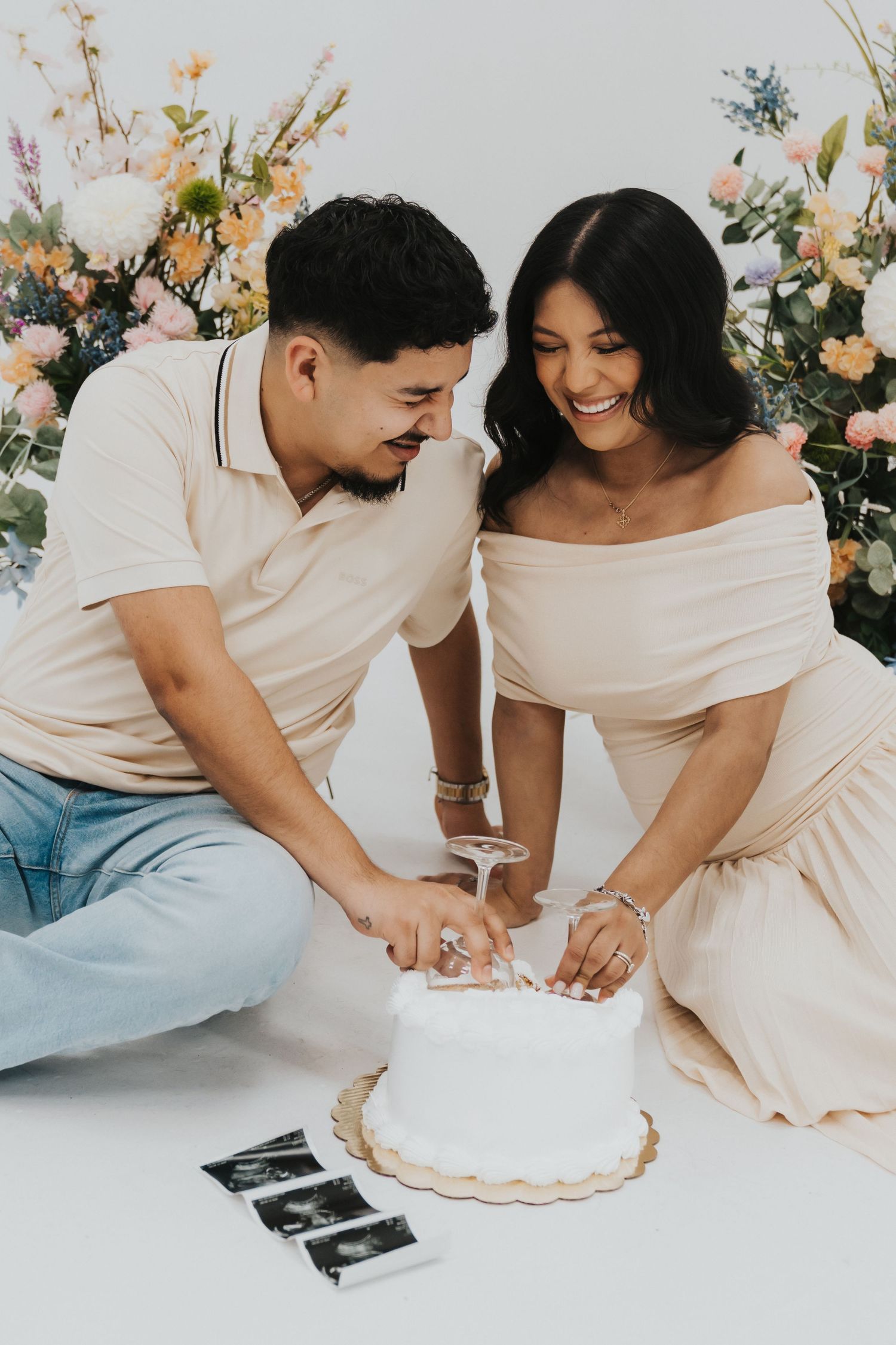 A couple shares an intimate moment while signing documents together with floral decorations in the background.