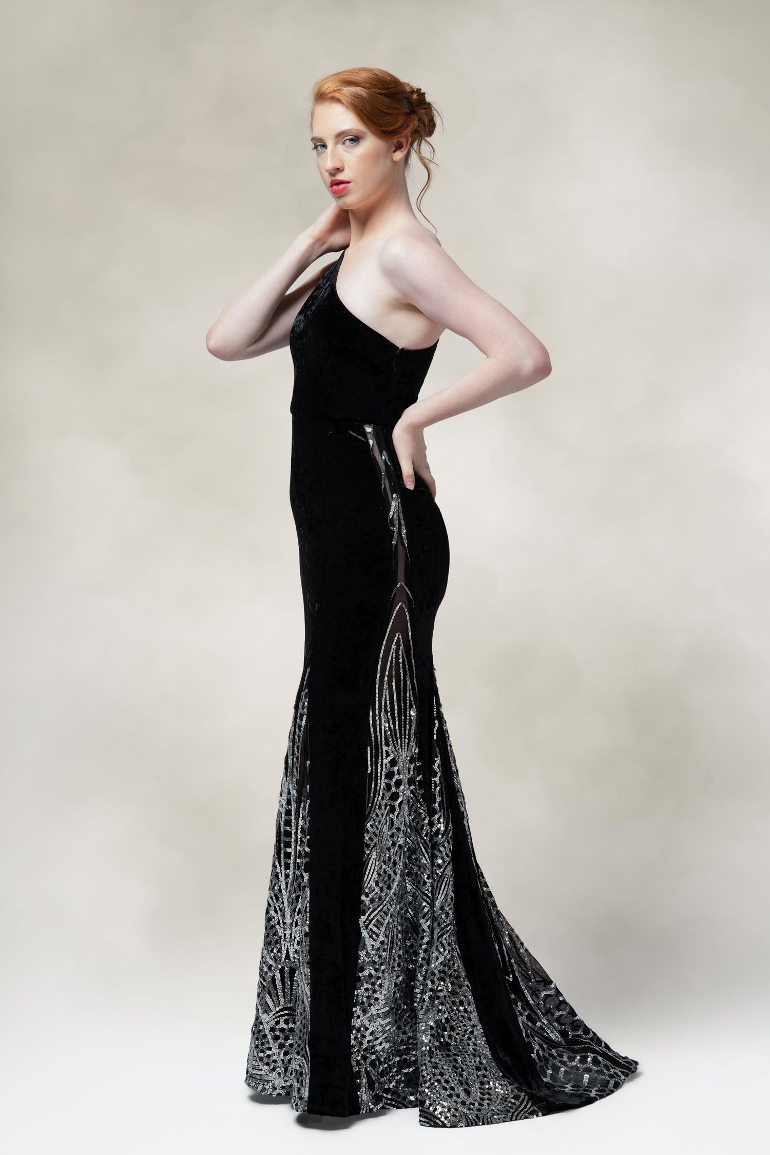 Elegant black velvet evening gown with silver embellishments features a mermaid silhouette and strapless neckline.