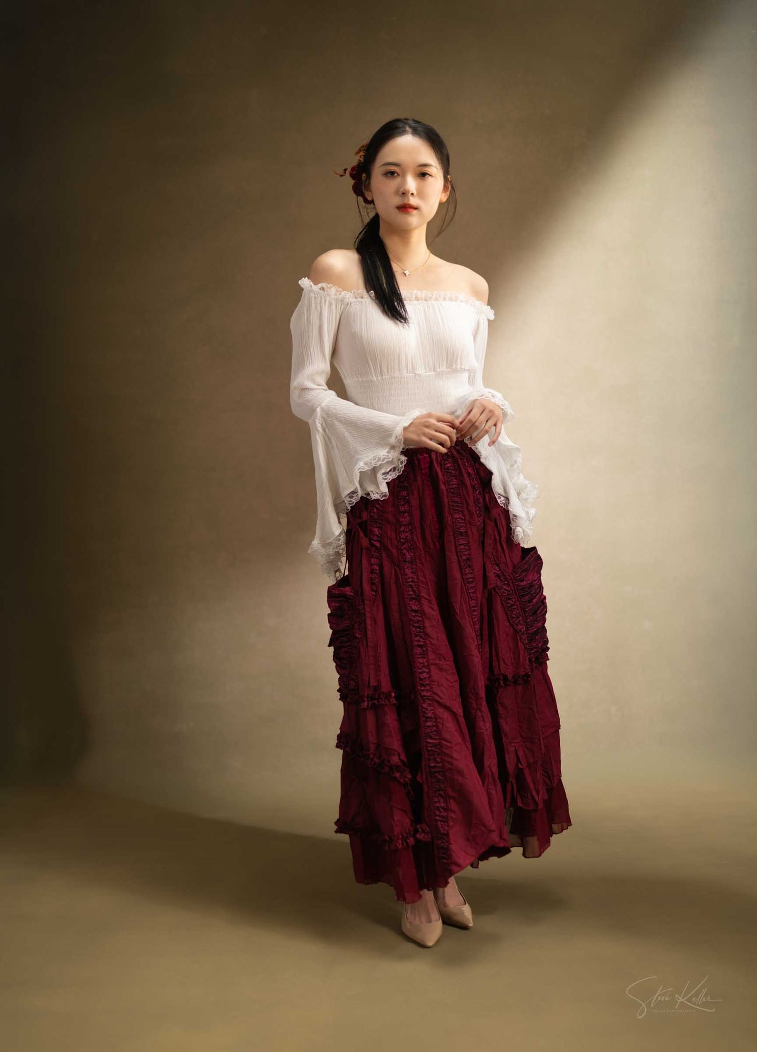 A model in a white off-shoulder top poses with a burgundy ruffled skirt in a series of elegant studio shots.