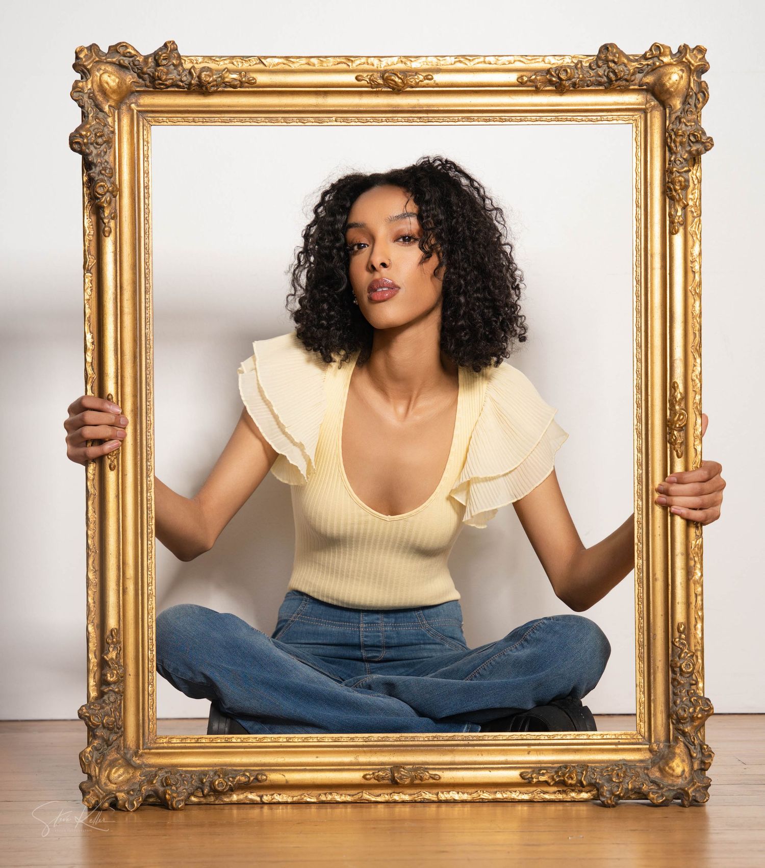 Creative portrait through an ornate gold frame with casual modern styling.