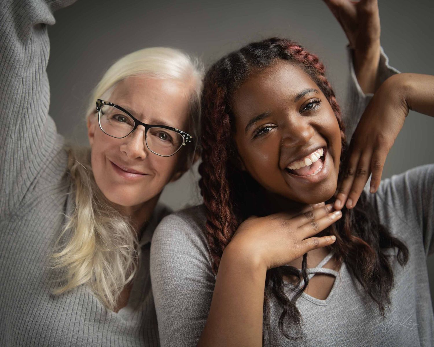 A candid portrait showing two people sharing a playful moment while wearing casual attire.