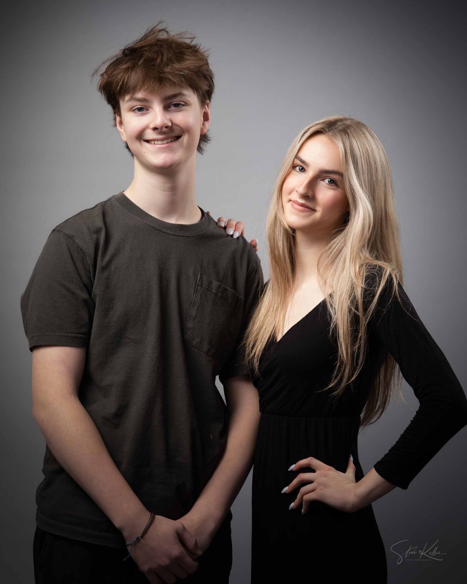 Two people pose together against a gray background in a series of candid studio portraits.