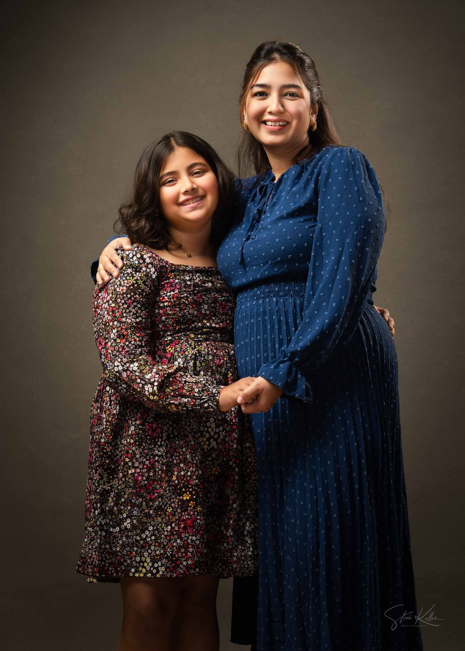 Five sequential photos show two people posing together against a dark backdrop in matching floral and blue dresses.