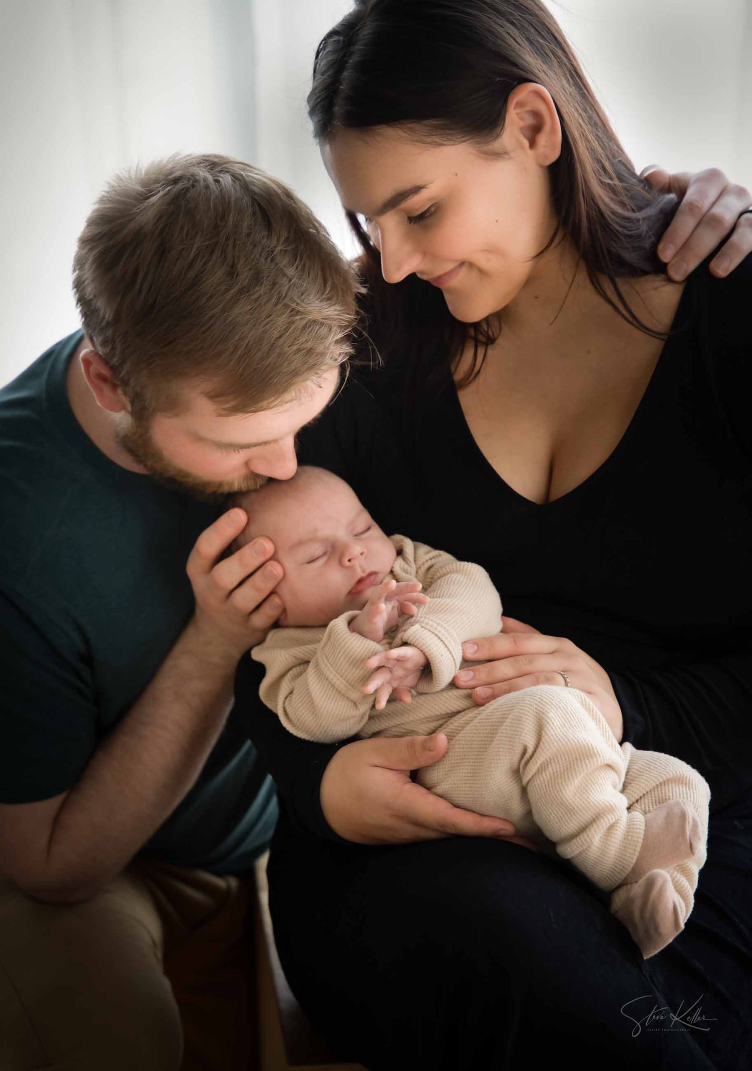 Tender moments captured between parents and their newborn baby in black and white studio portraits.