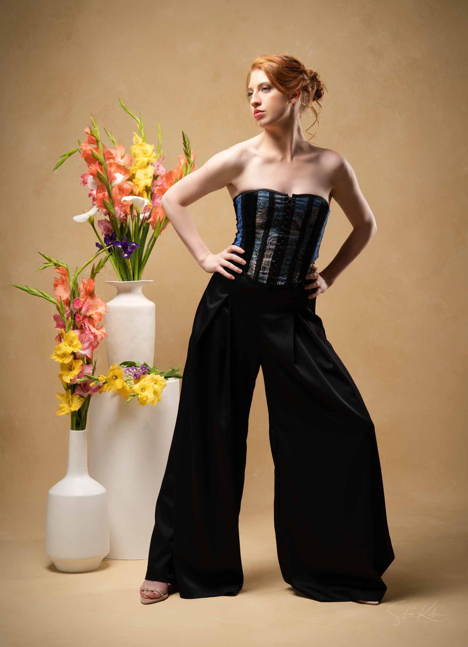 Studio fashion series featuring black corset style outfit with white ceramic vases and colorful floral arrangements.