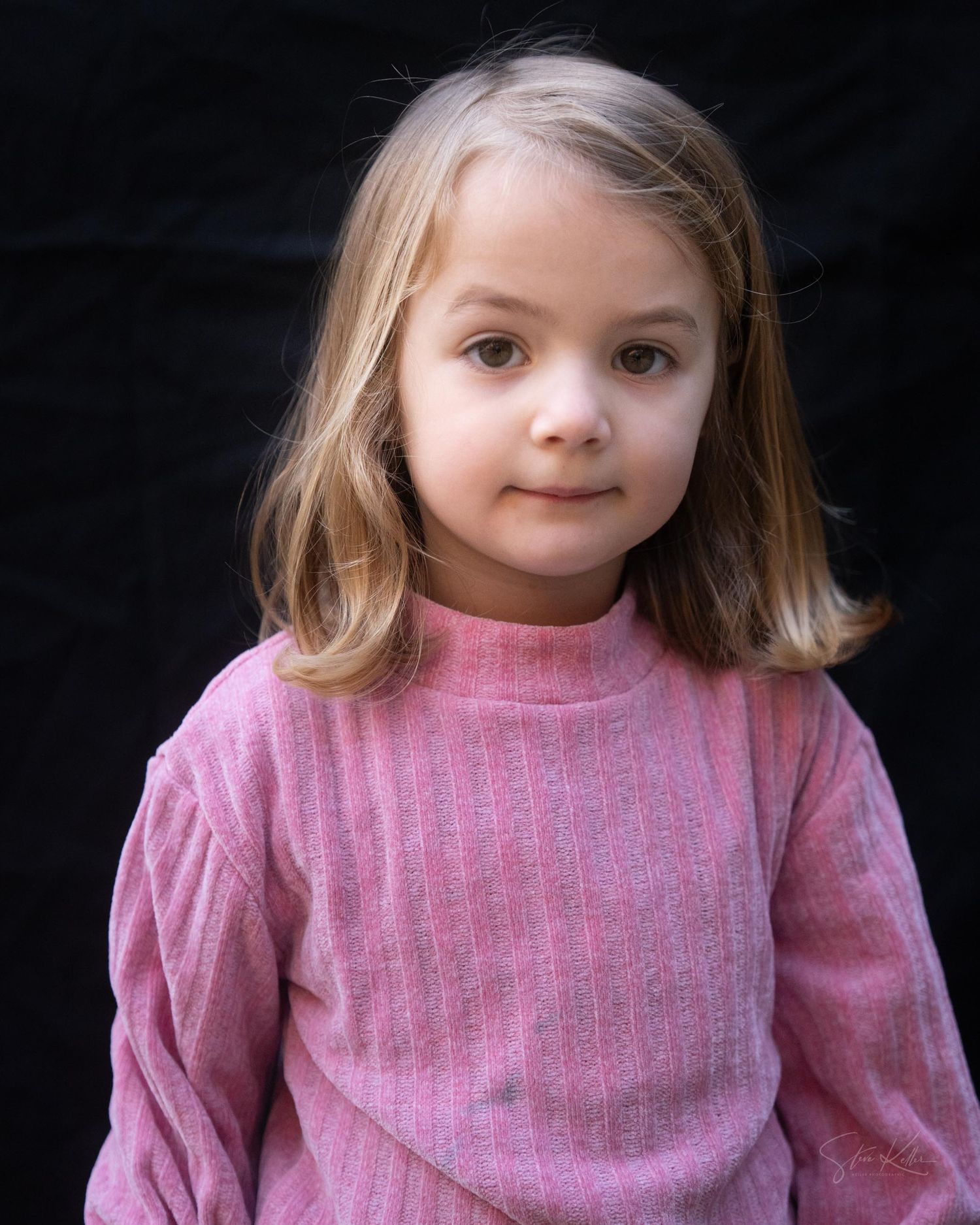 A child wearing a pink striped sweater poses with different expressions in a series of candid portraits.