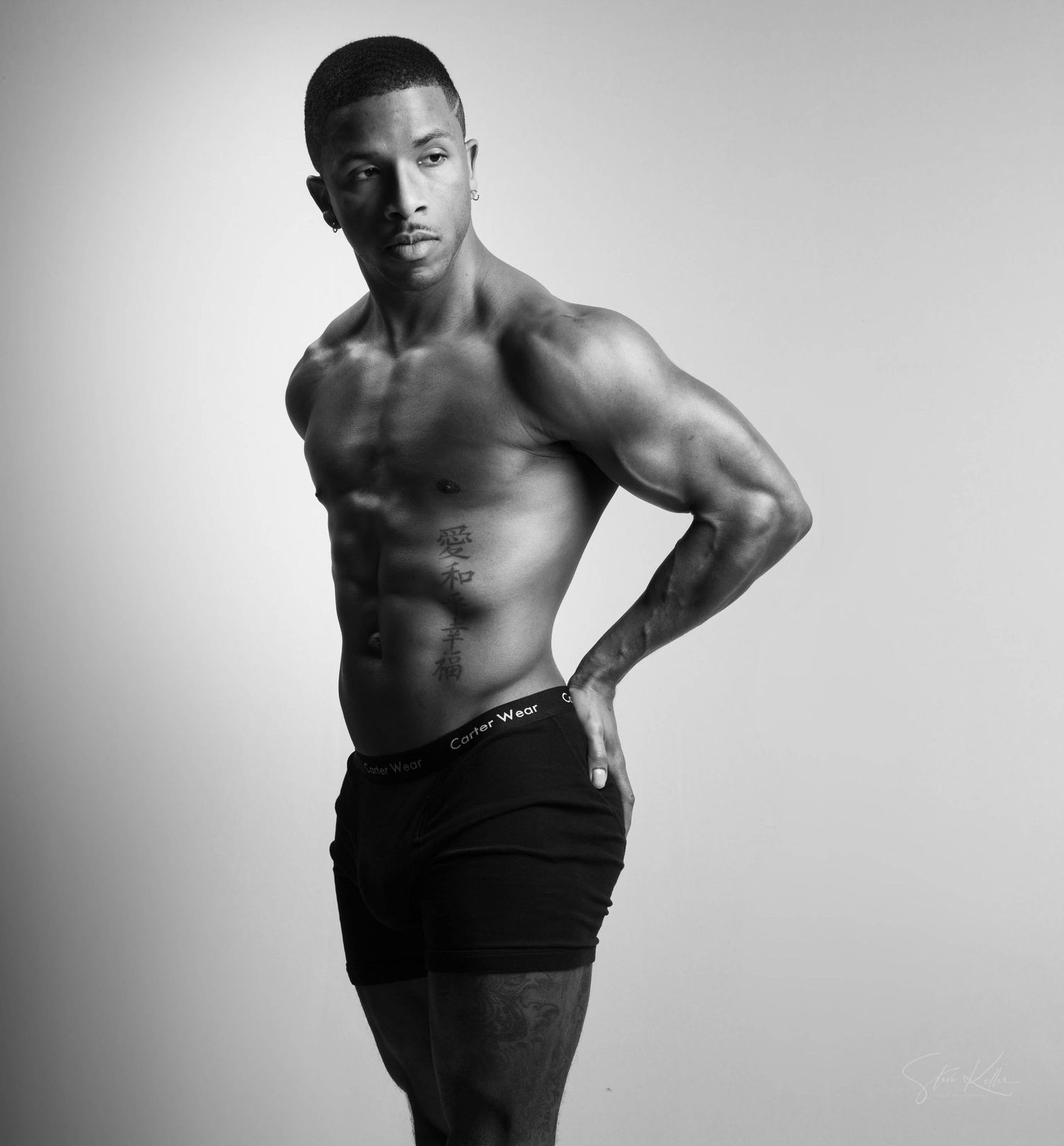 Black and white artistic portrait series showing athletic physique in dramatic lighting and poses.
