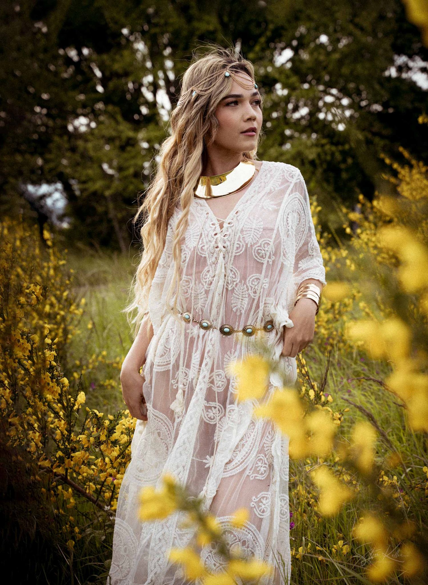 Ethereal white lace dress photographed in a dreamy outdoor setting with golden sunlight filtering through trees.