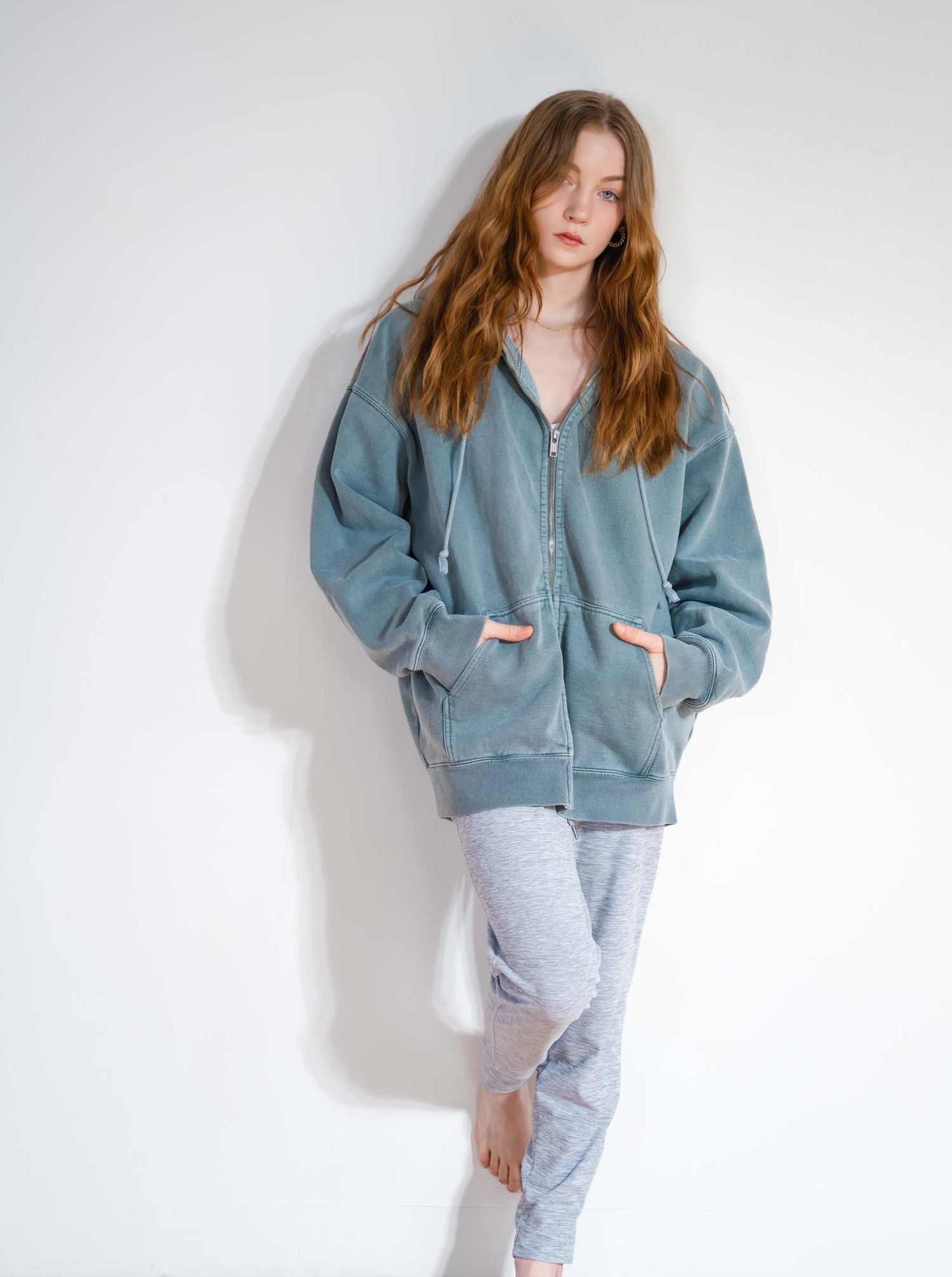 Fashion photo series showing casual loungewear styling with an oversized blue zip-up hoodie and gray sweatpants.