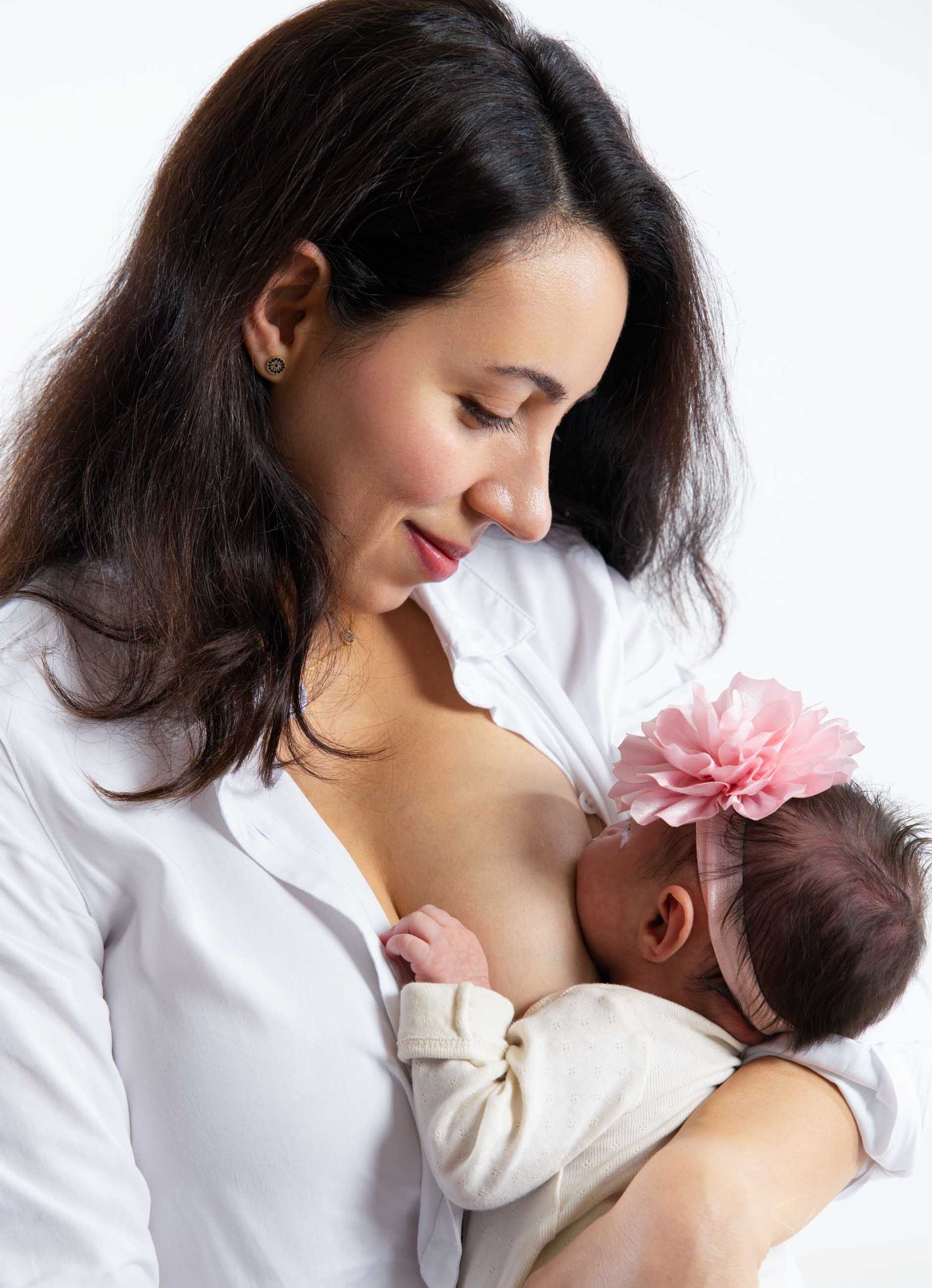 Artistic black and white series showing nurturing moments between mother and infant against white backdrop.