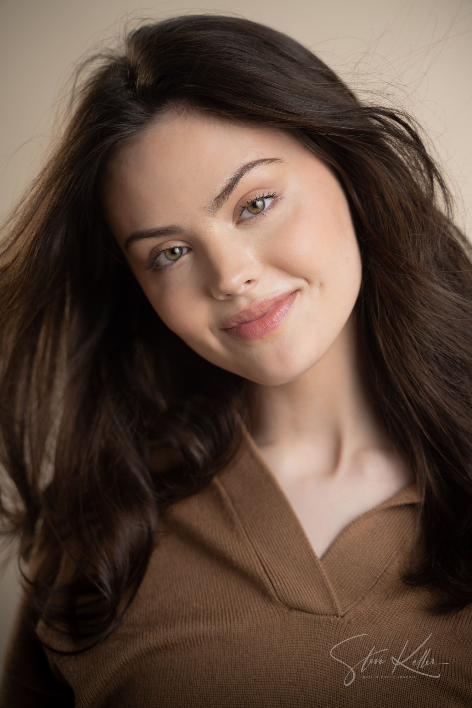 Warm toned portrait featuring soft lighting and brown v-neck sweater.