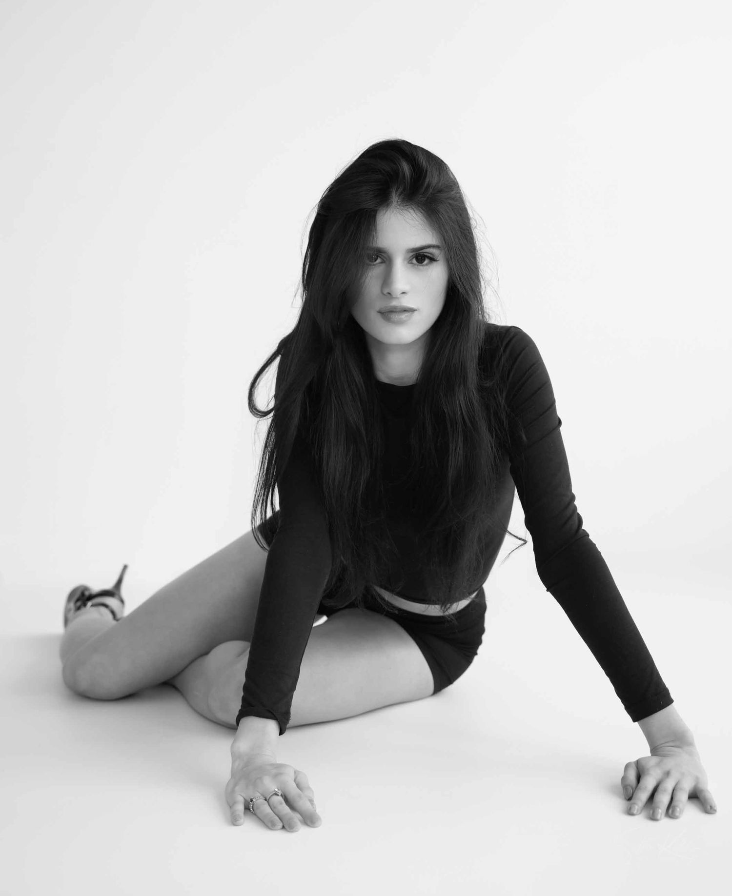 A series of black and white artistic photos showing a figure in a black top posing gracefully on a white background.