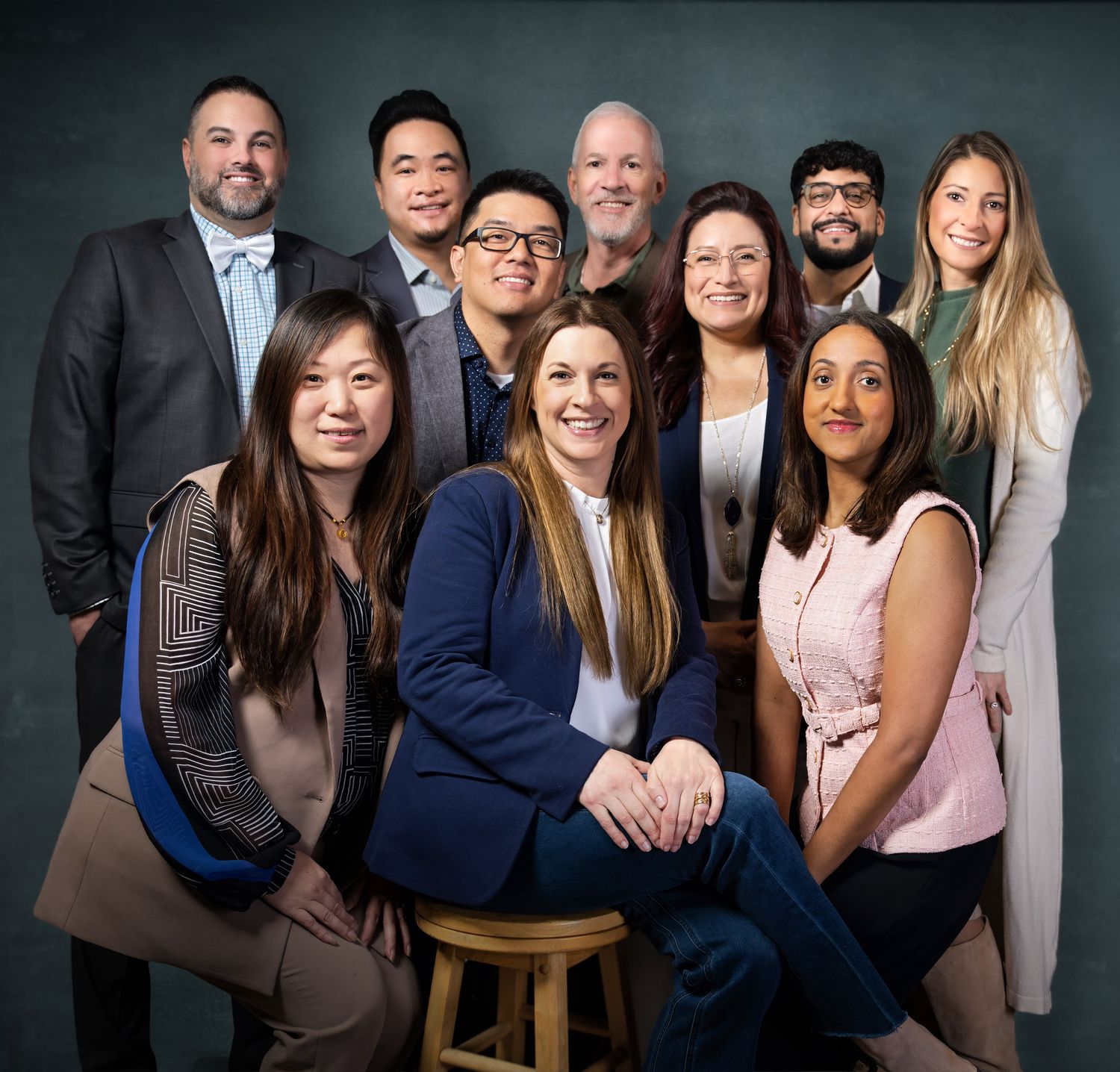 Diverse professional team of ten colleagues posing together for a formal group portrait photo.