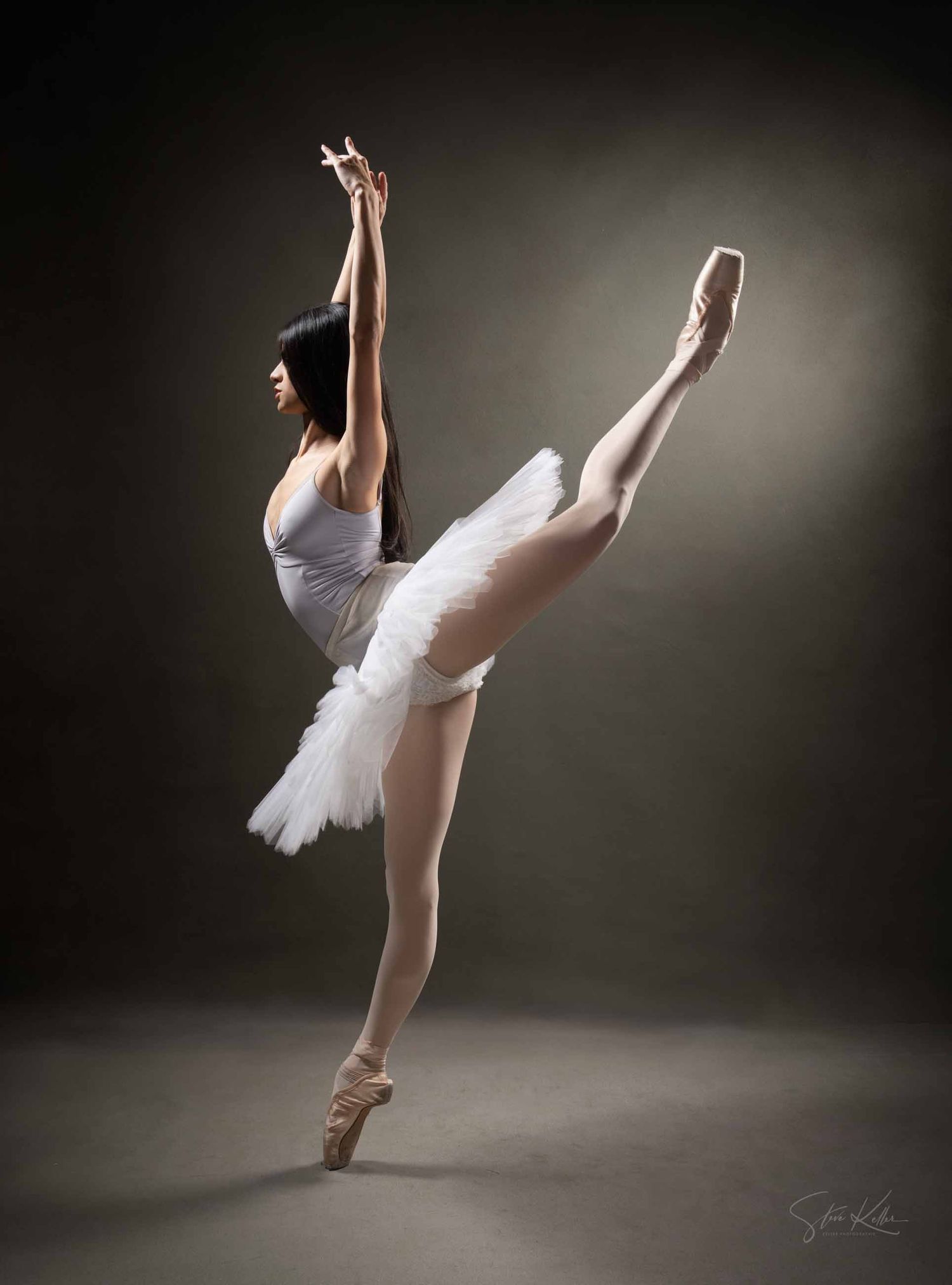 Ballet dancer in white tutu performs graceful movements against dark background in artistic photo series.
