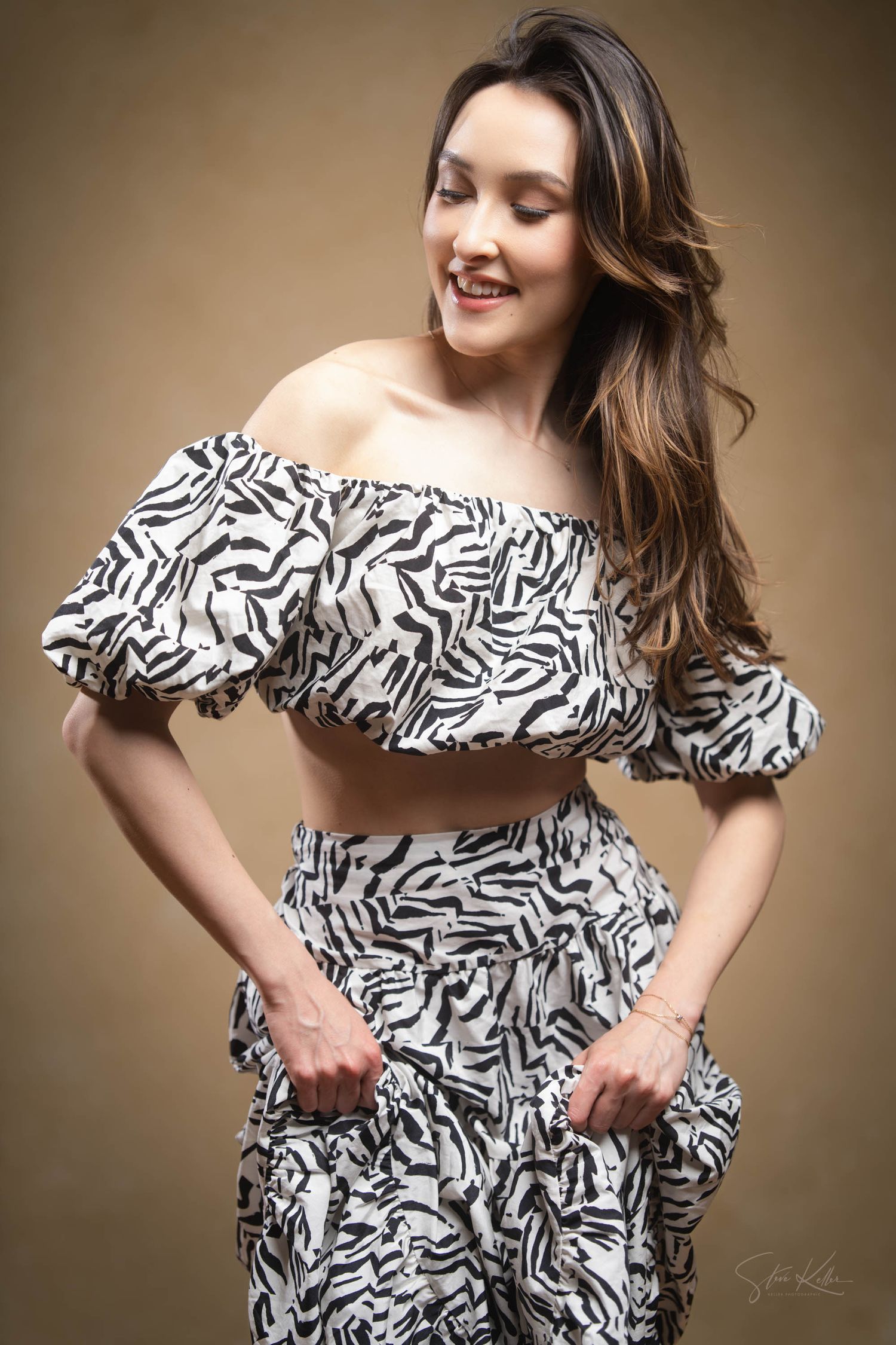 A stylish portrait of an off-shoulder crop top and matching pants in black and white zebra print pattern.