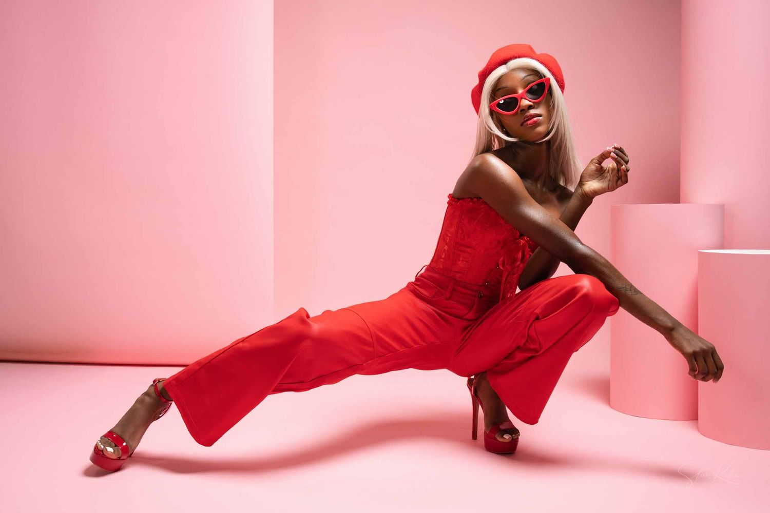 Dynamic fashion photo series showing a model in red against a pink backdrop performing energetic dance poses.