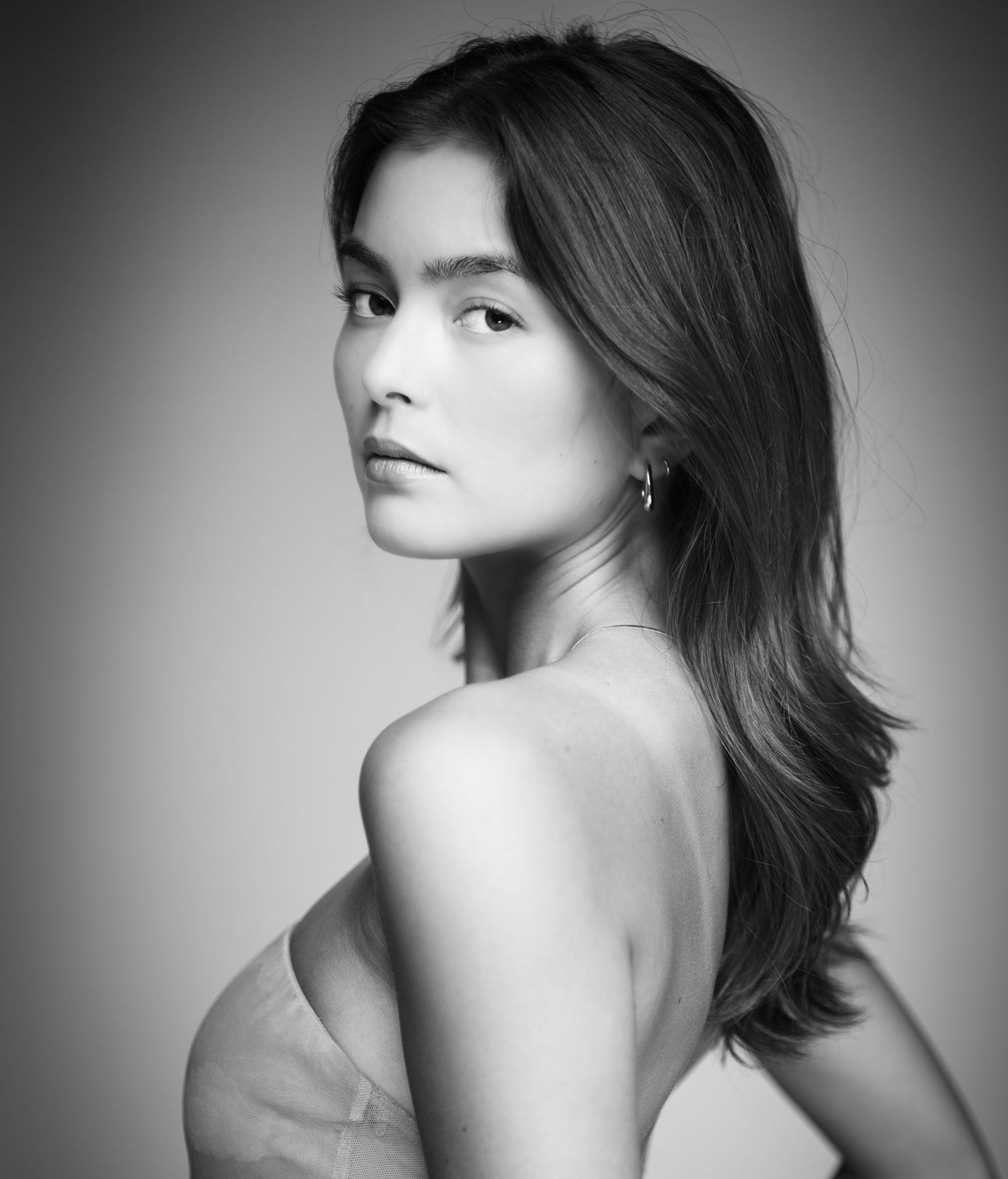 Dramatic black and white beauty portrait with bare shoulder pose.