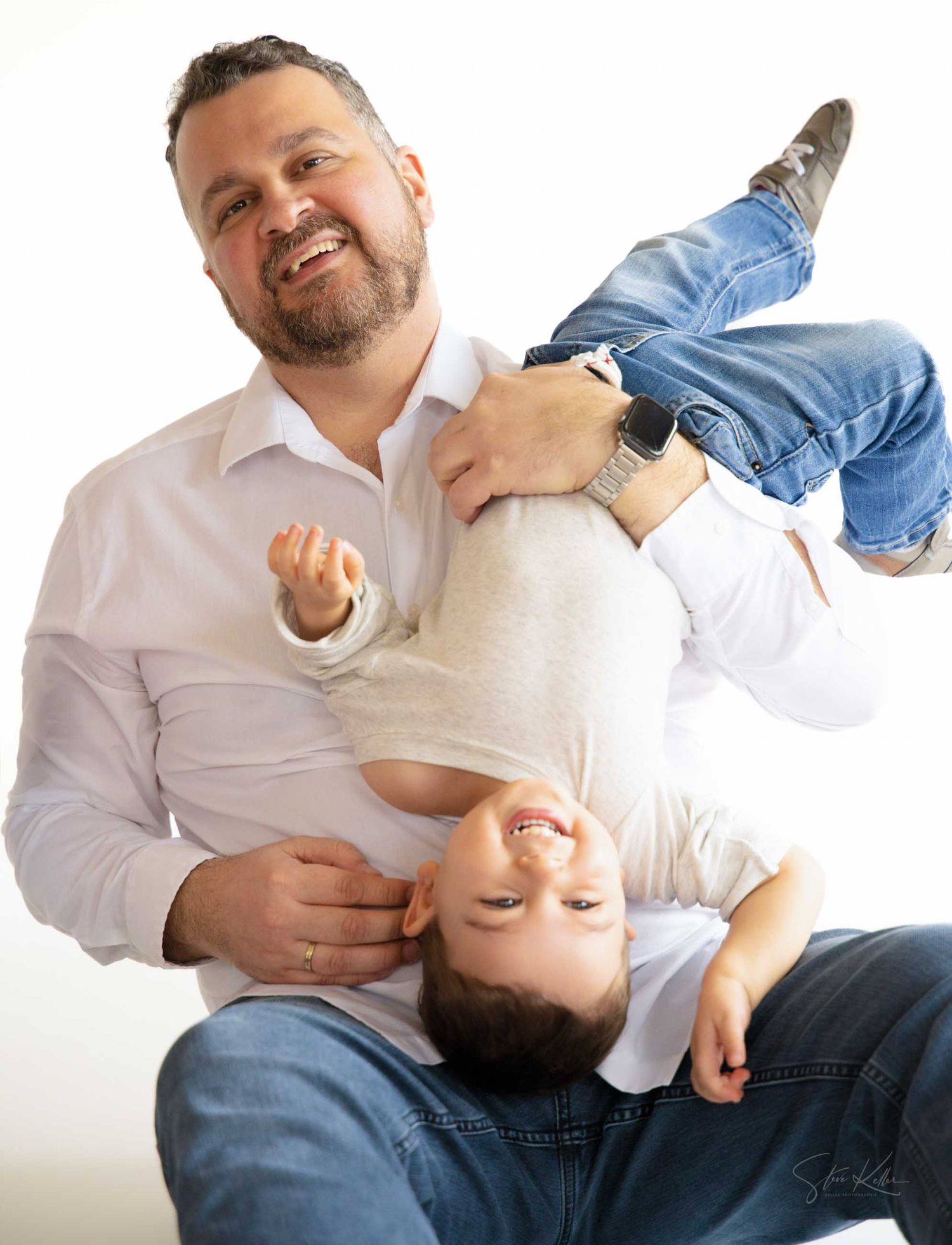 A sequence of four similar photos showing a person in white shirt lying back and smiling while holding a baby in blue clothing.