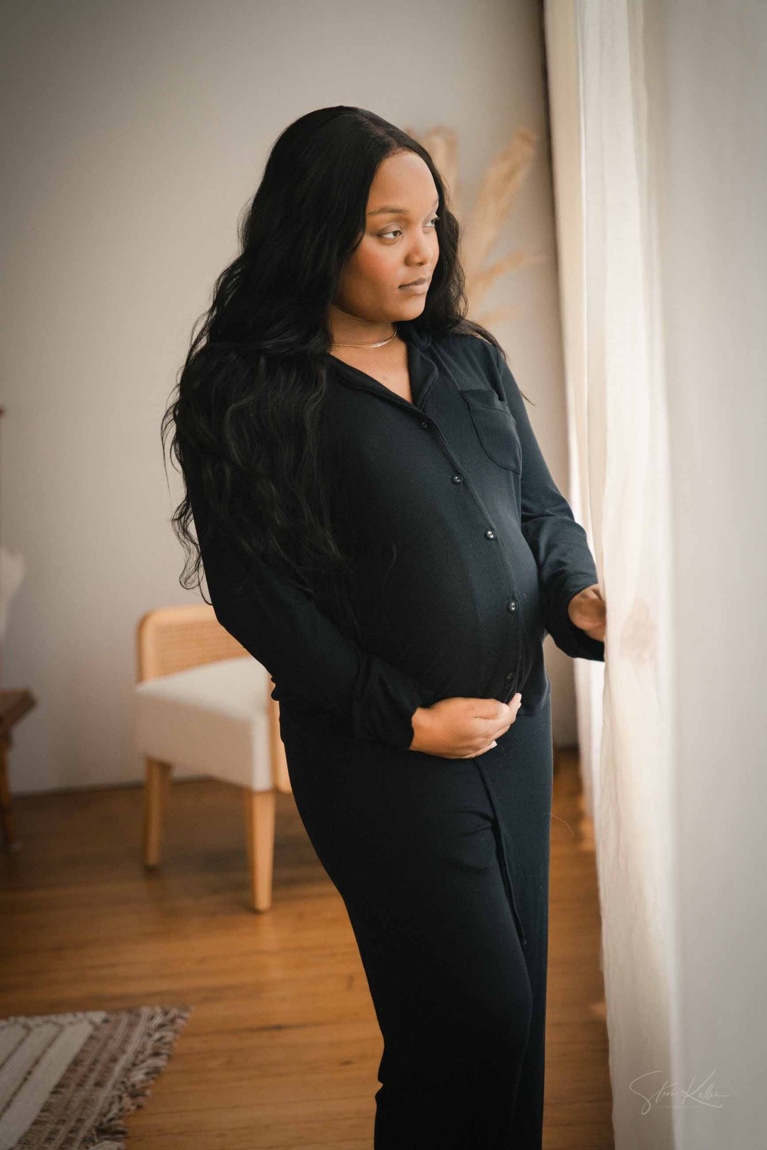 A person wearing a black dress poses against a white wall in a series of lifestyle photos with wooden flooring.