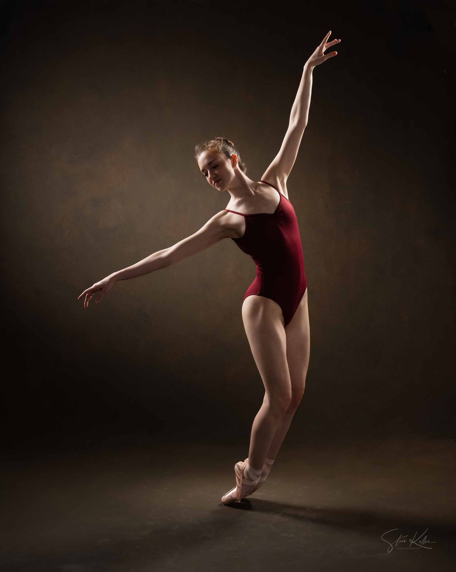 A ballet dancer in red leotard performs a graceful sequence of movements against a dark background in studio lighting.