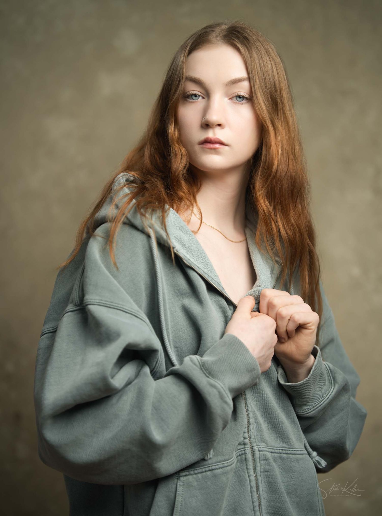 Fashion portrait series showing person wearing baggy grey jacket against textured backdrop.