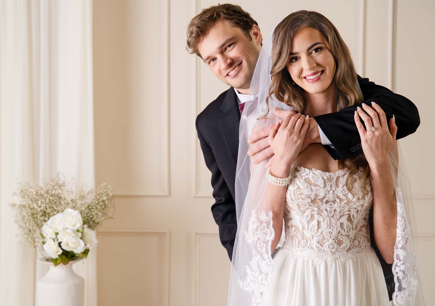 A bride and groom share a joyful laugh together during their wedding photo session.