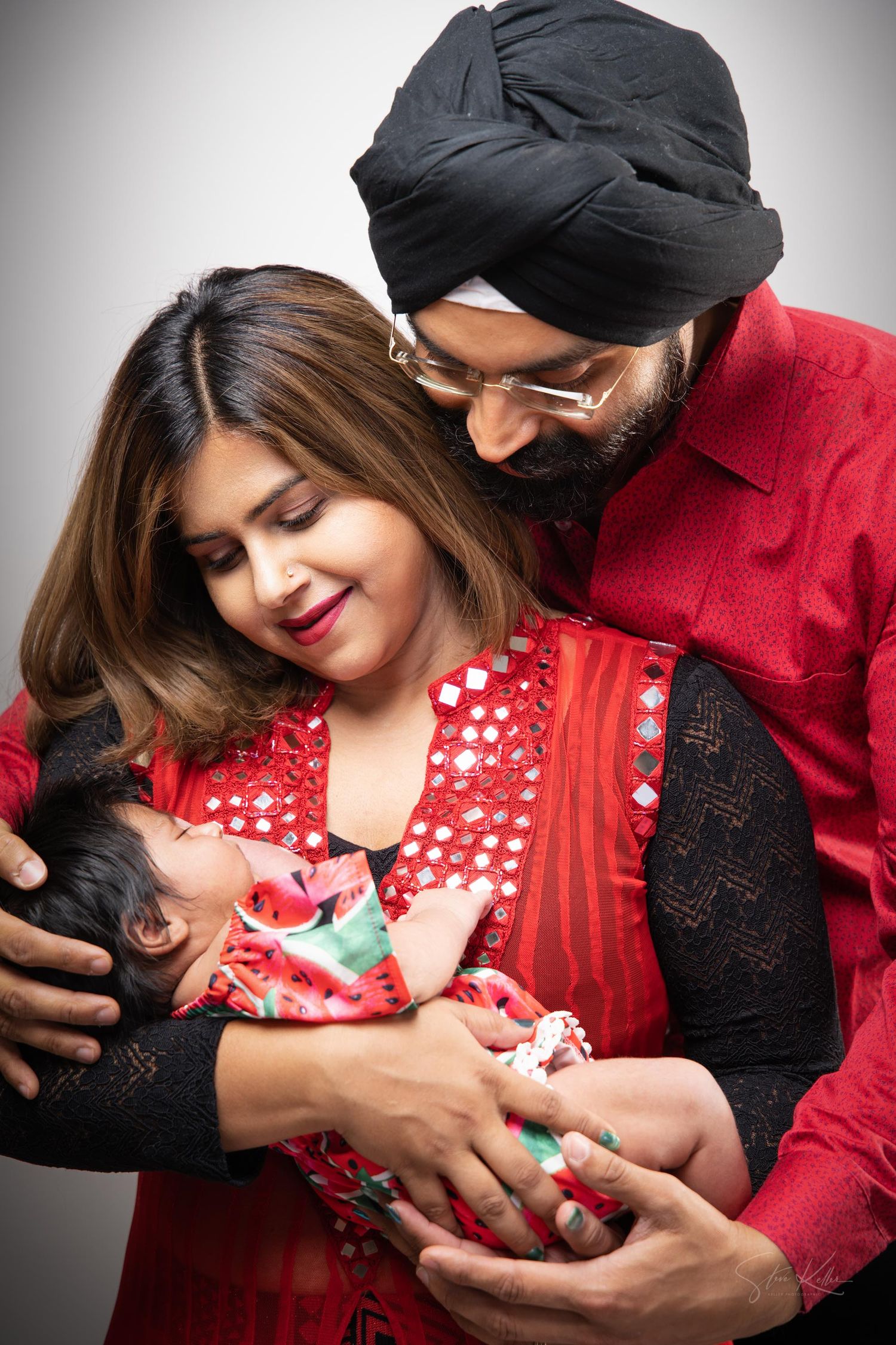 A sequence of tender family moments showing parents holding and bonding with their newborn baby in matching red outfits.