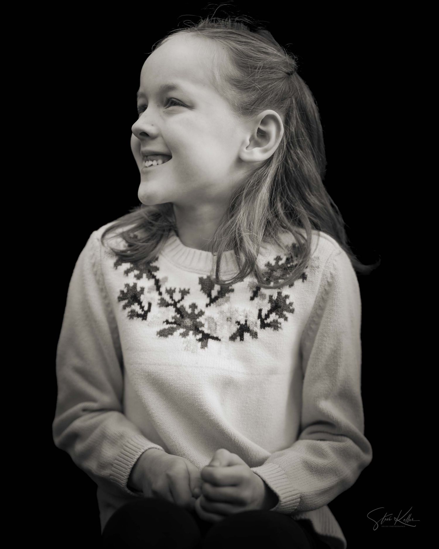 A black and white photo series showing a child in a white sweater with decorative collar smiling and turning to the side.