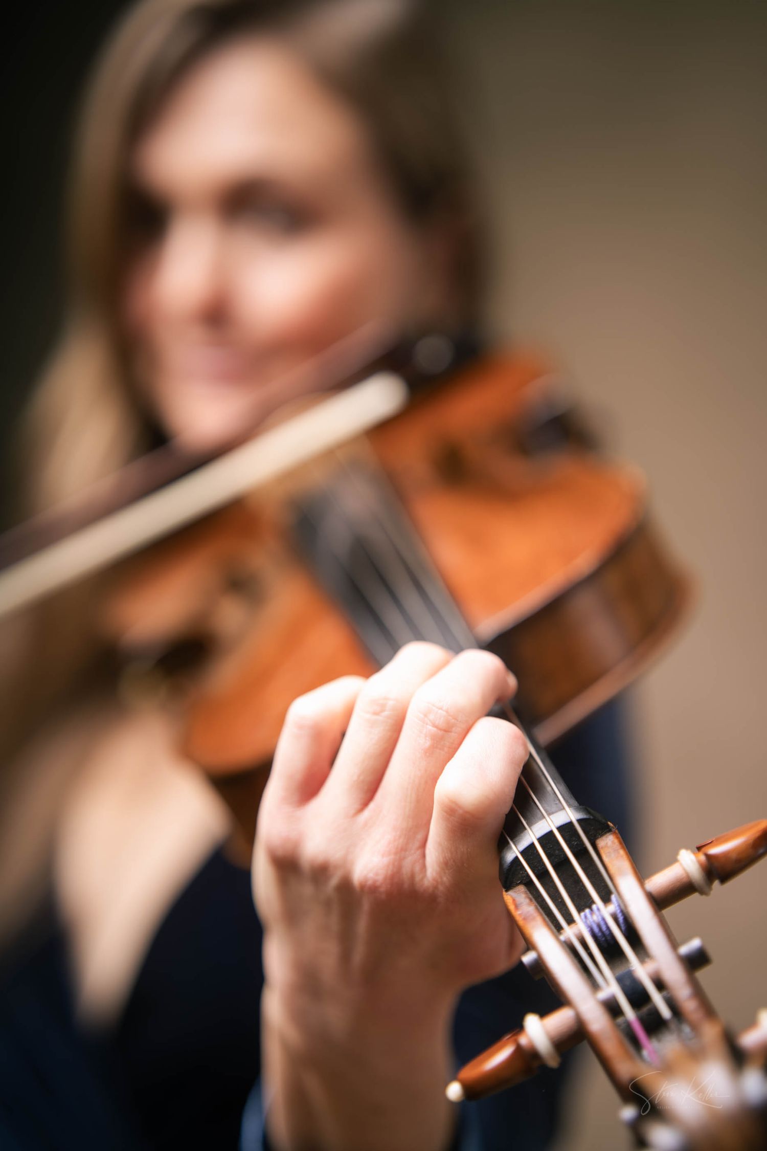 A sequence of close-up shots showing a violinist performing with their instrument in warm lighting.