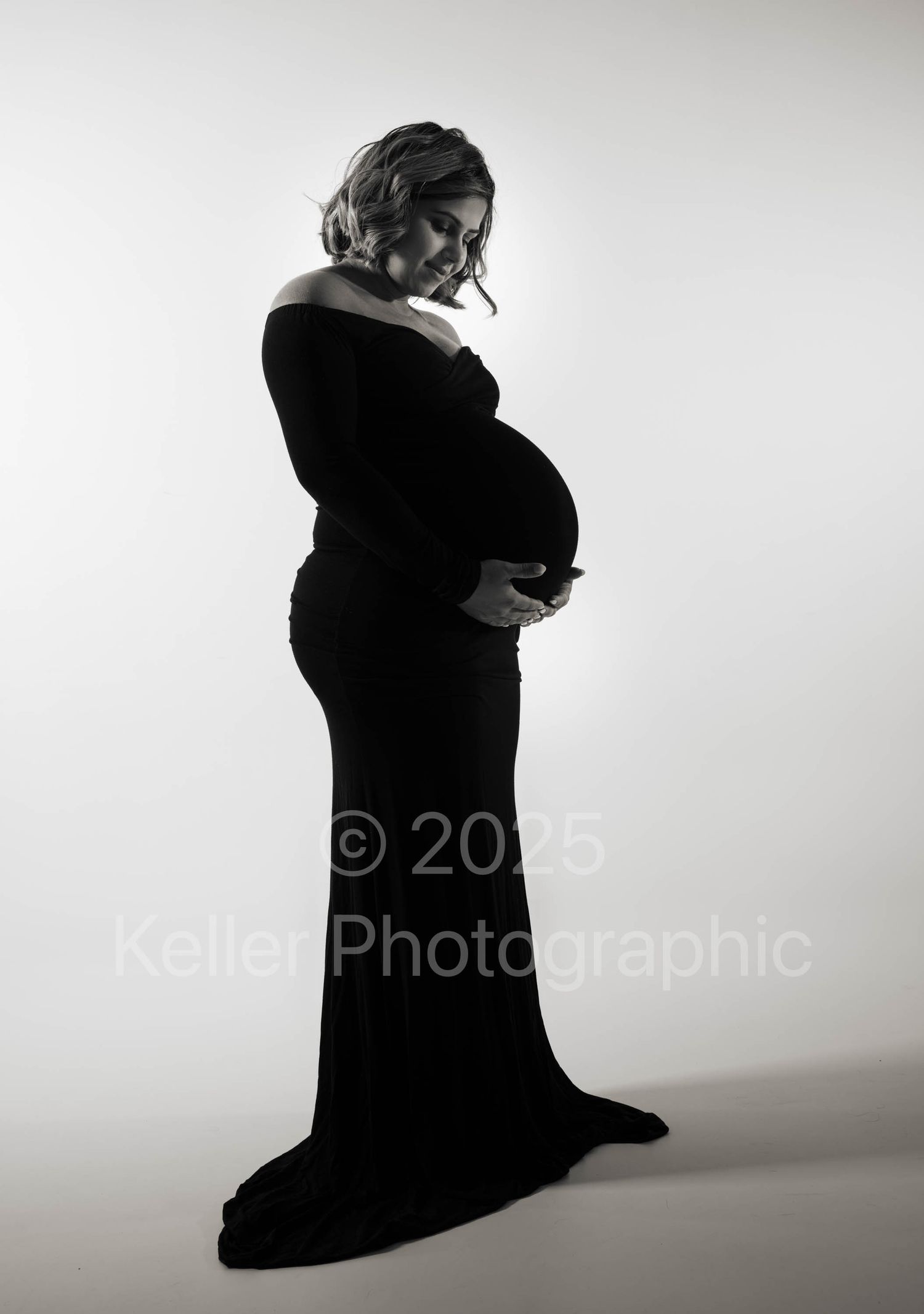 Artistic black and white silhouette series capturing pregnant woman's form in flowing dark dress.