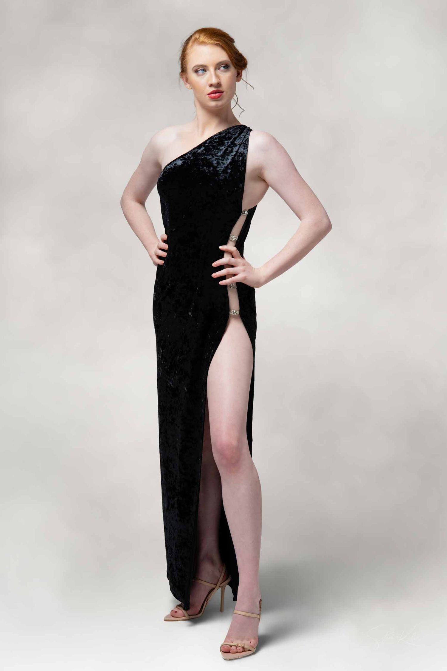 Model in a black asymmetrical dress poses against white background in a series of artistic fashion shots.