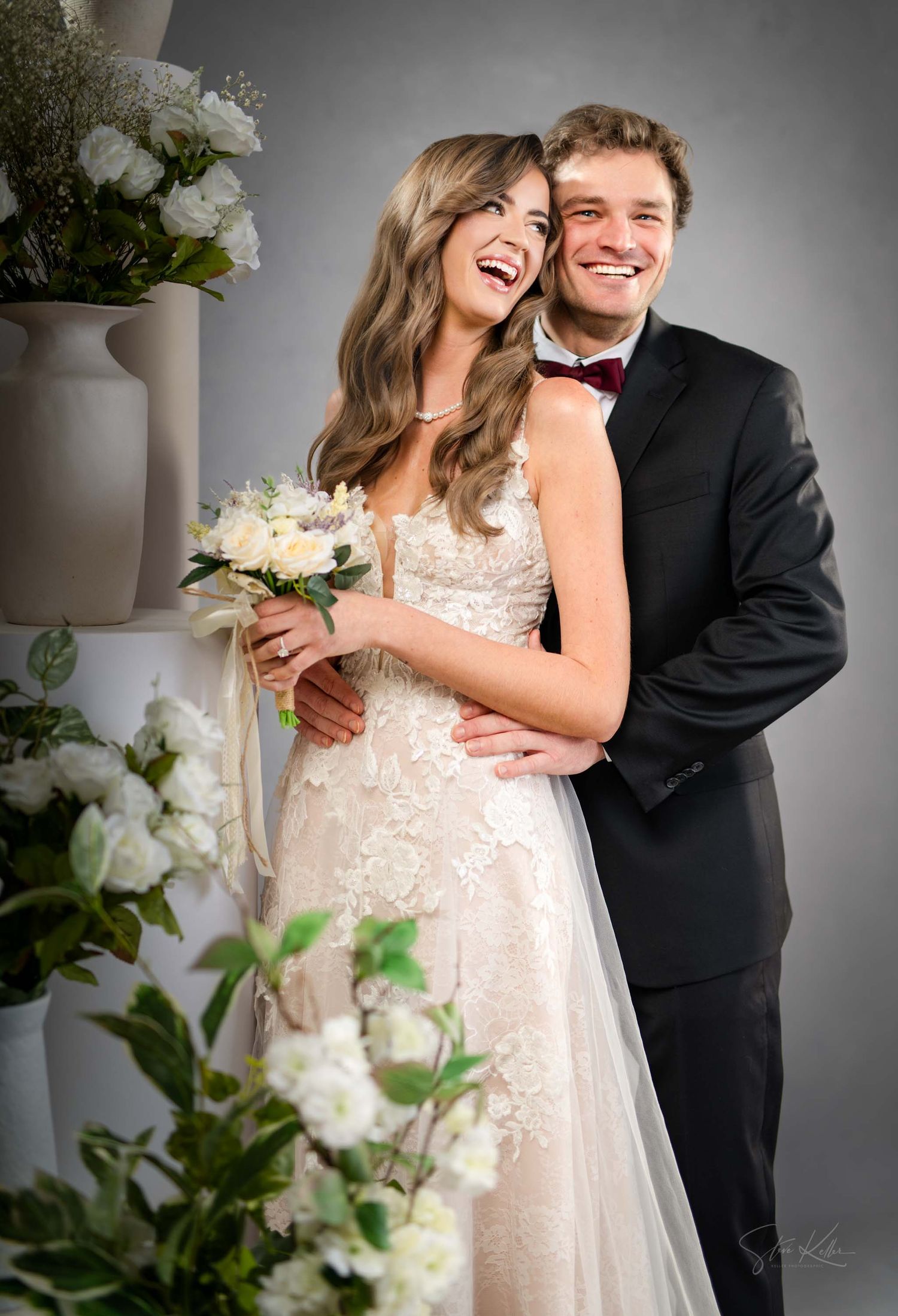 A joyful wedding couple shares candid laughs together in a series of black and white studio portraits.