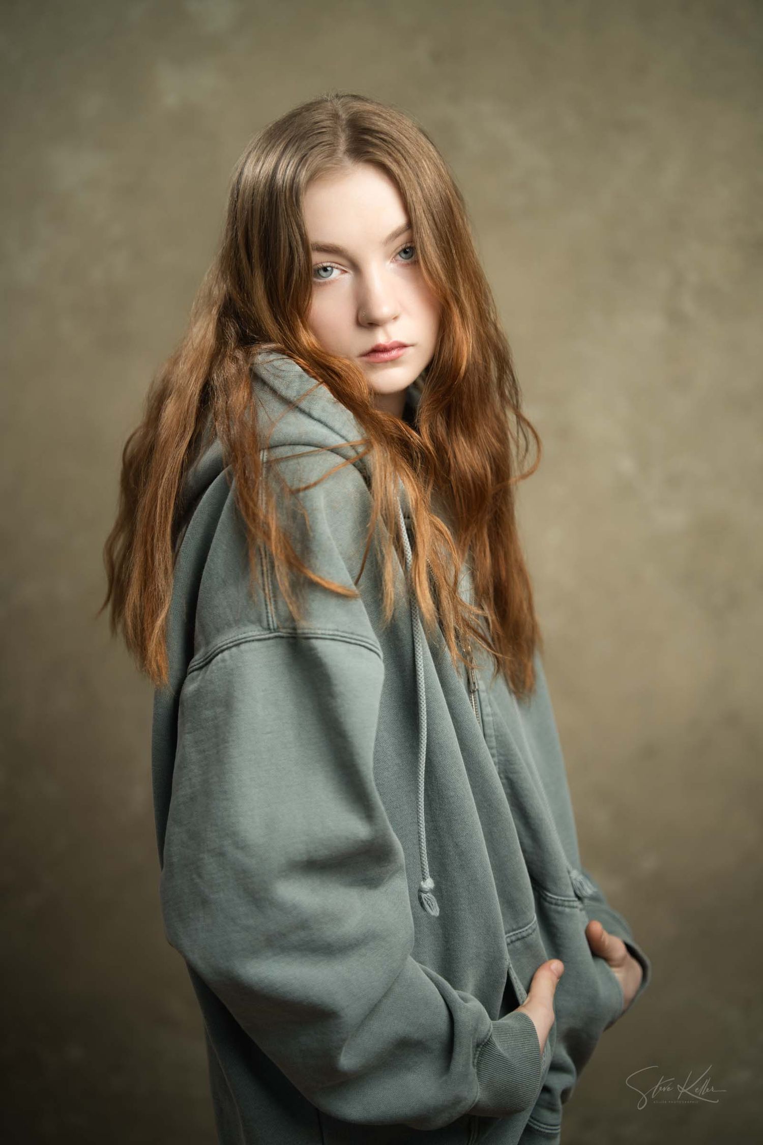 Fashion photo series showing casual loungewear in sage green hoodie against textured wall background.