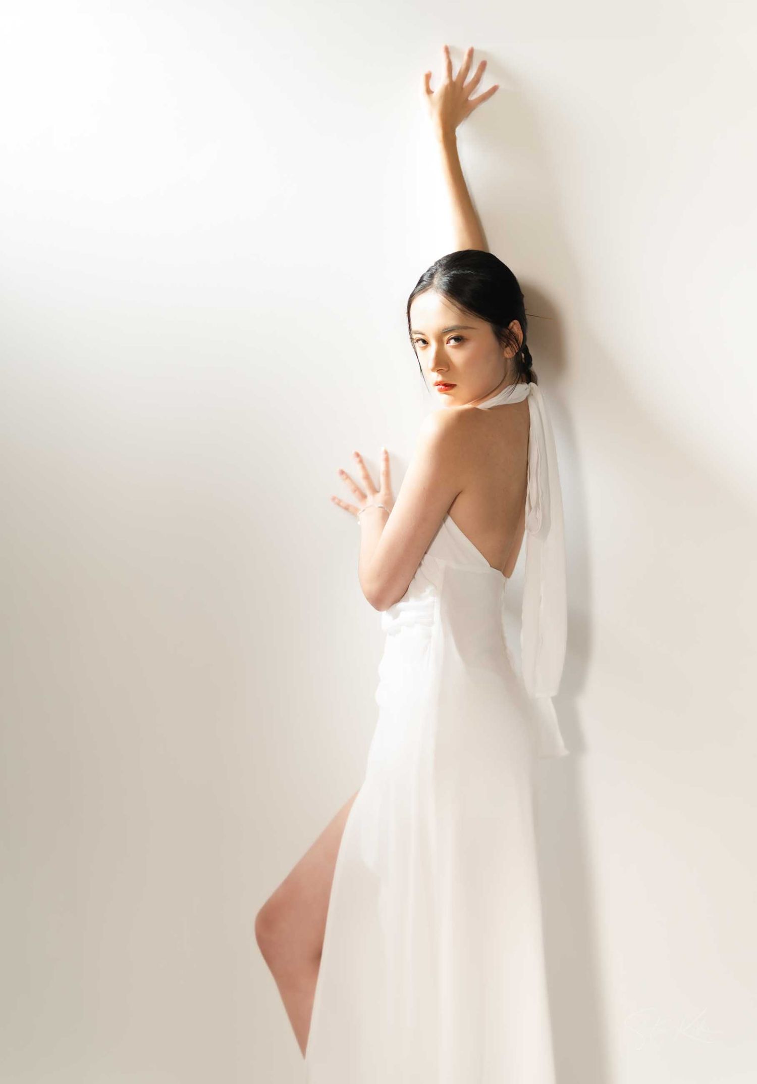 Minimalist artistic portraits featuring a white veil and dress against a light background with graceful poses.