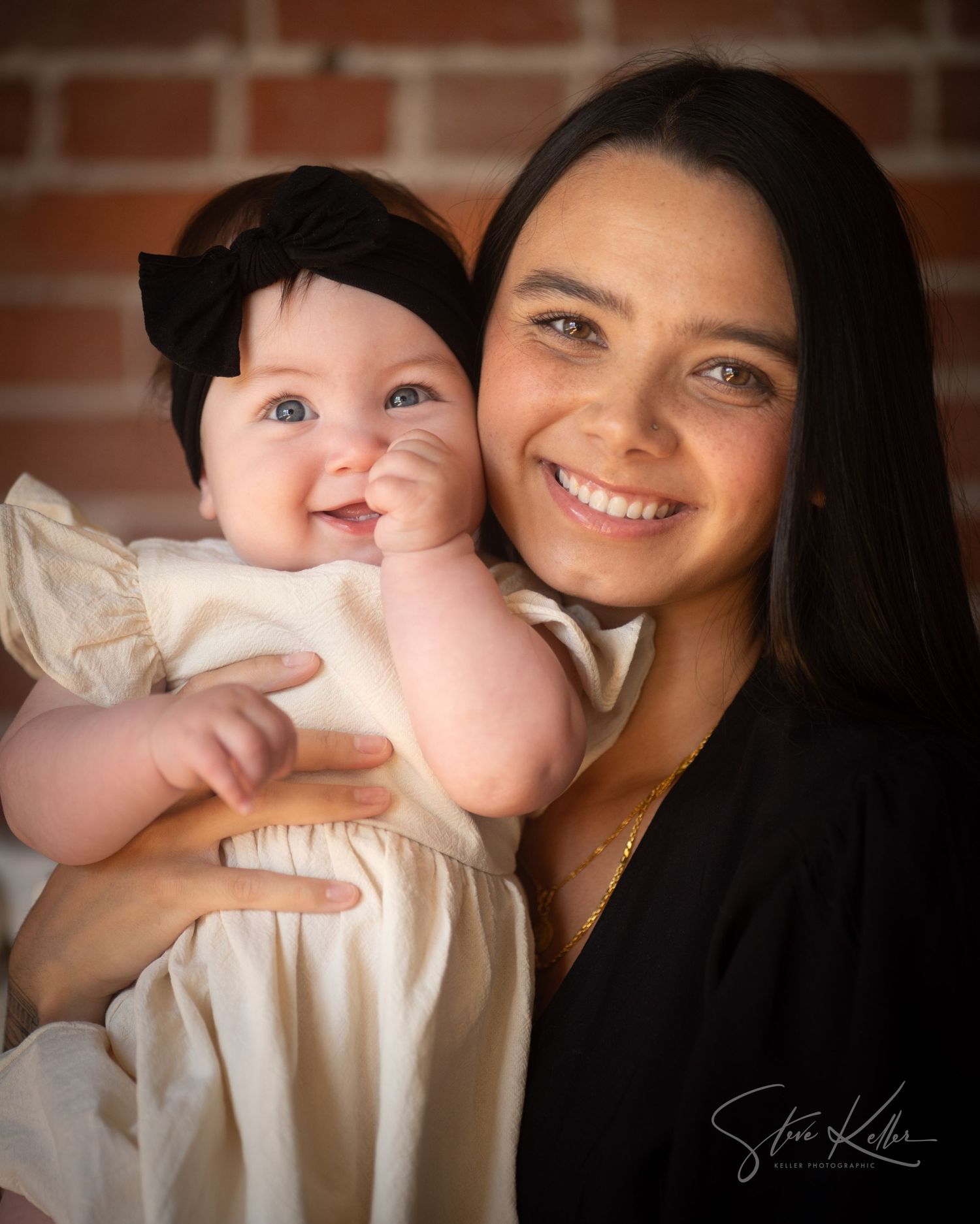 Heartwarming indoor portrait of a mother and baby in natural window light.