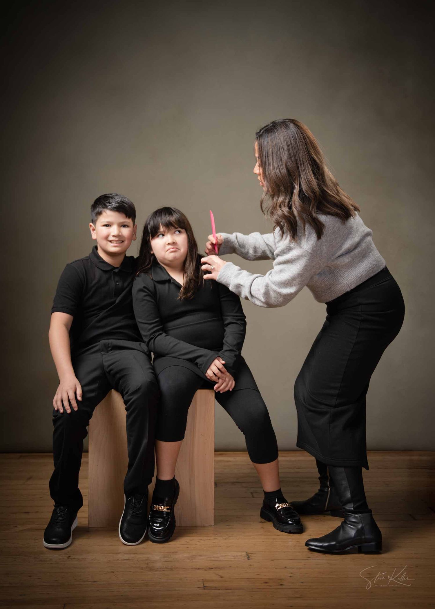 A sequence of five photos showing two people in black outfits interacting playfully on a wooden floor against a dark background.