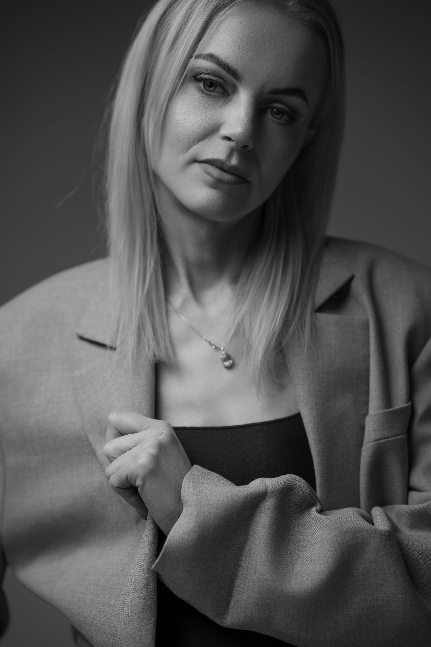 A series of black and white portraits showing a person with blonde hair in different poses and expressions.