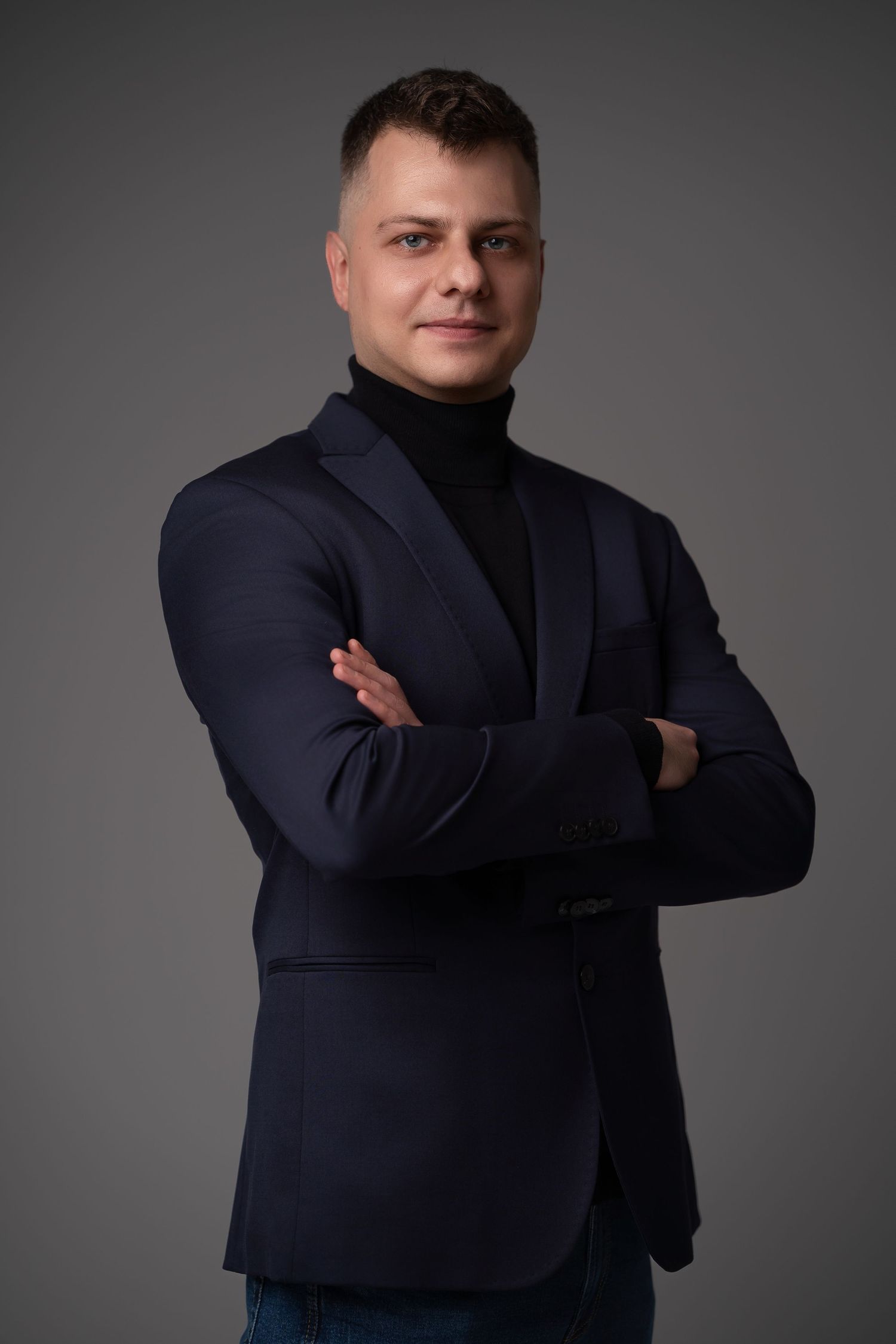Professional studio portrait series showing person in navy suit jacket against gray background in various poses.