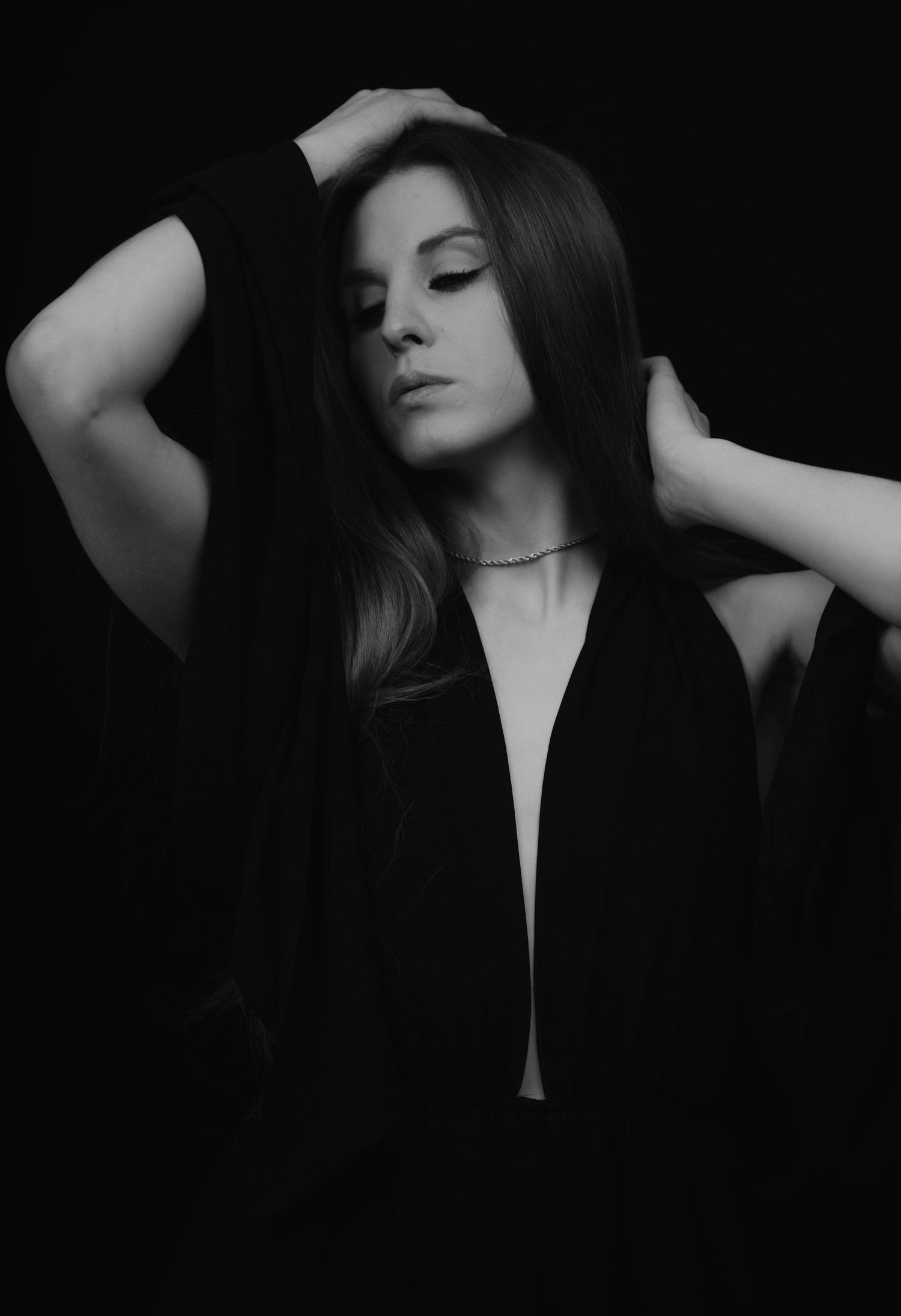 Moody black and white portrait of model in plunging neckline dress.